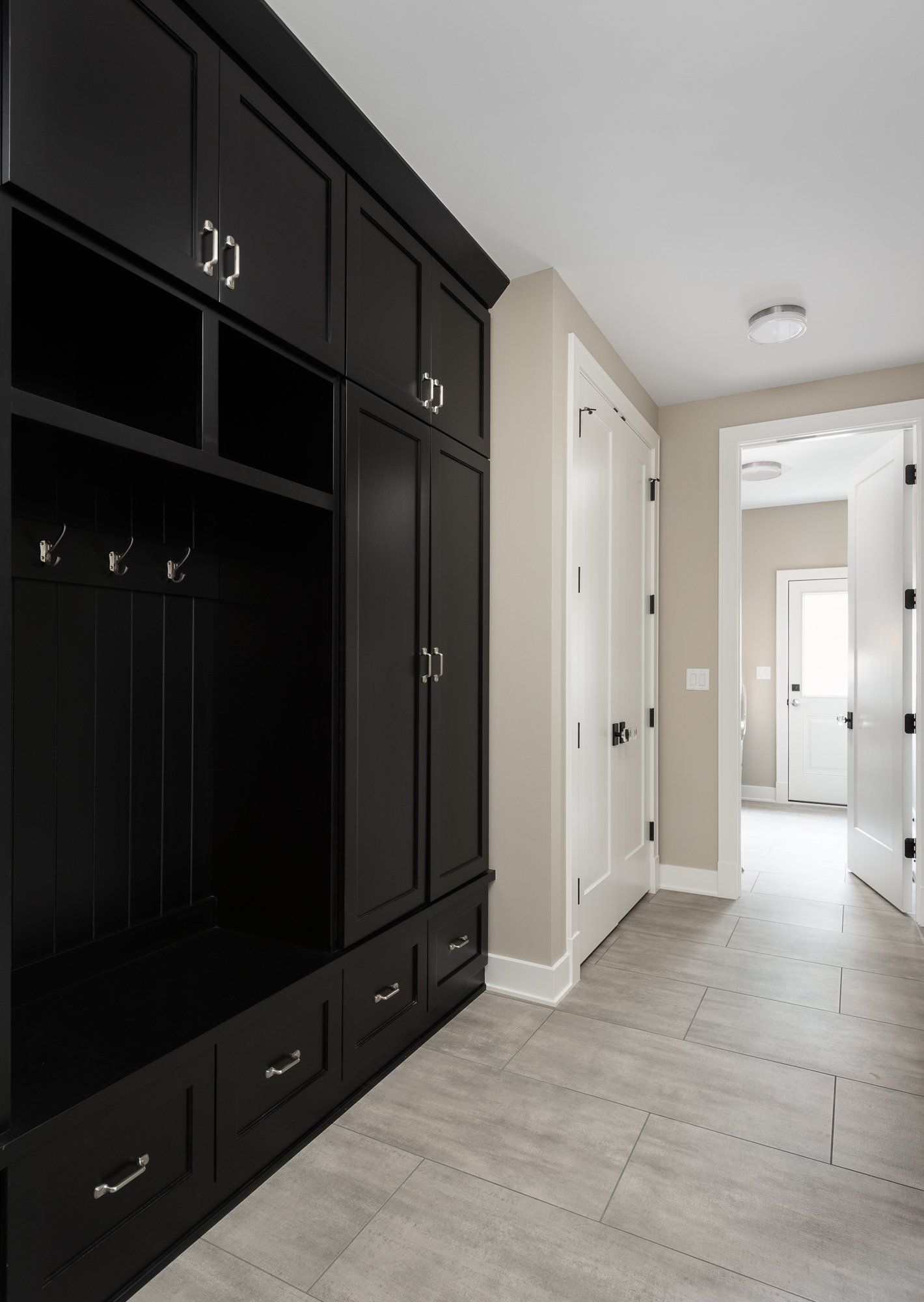 A hallway in a house with black cabinets and drawers
