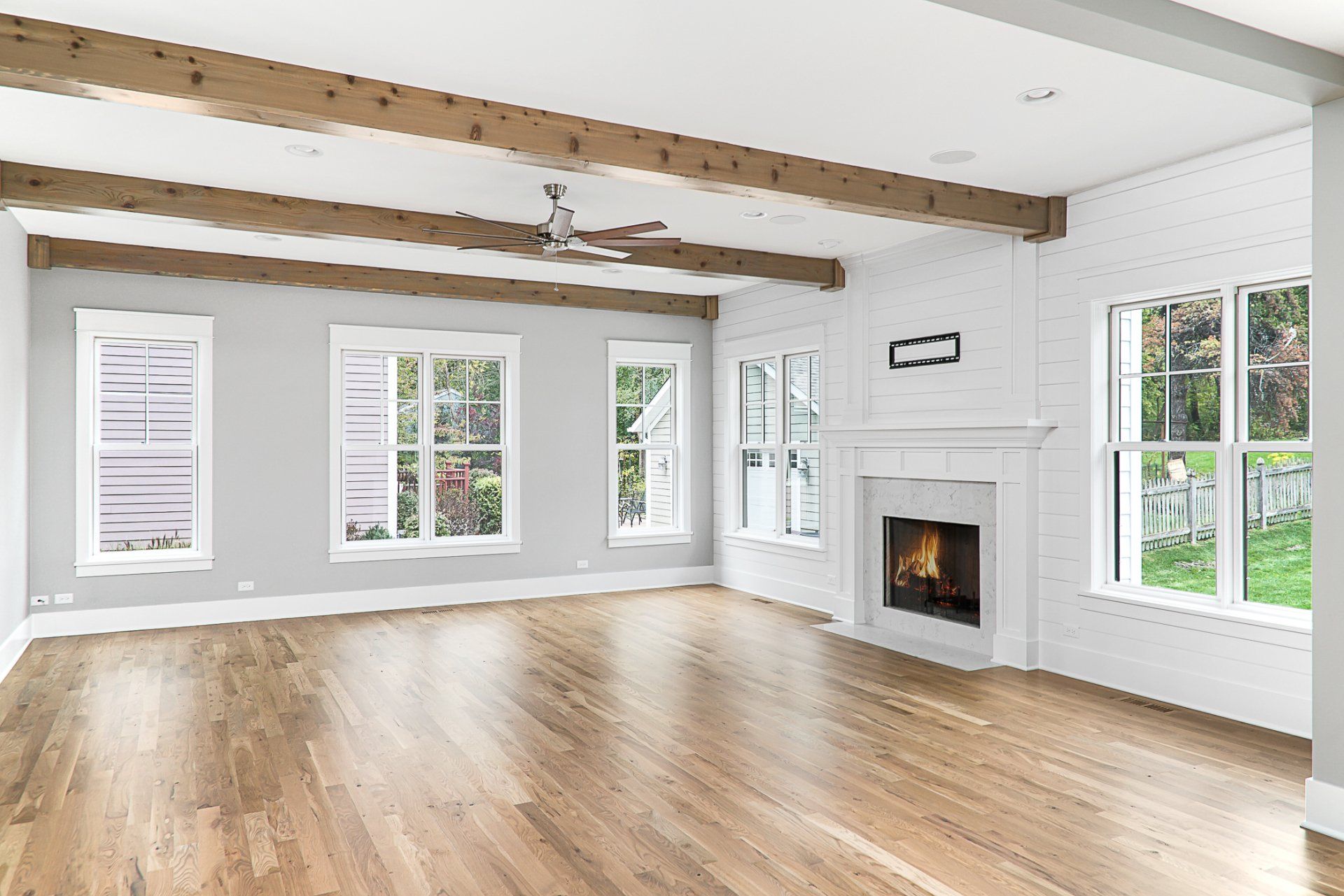 An empty living room with hardwood floors and a fireplace.