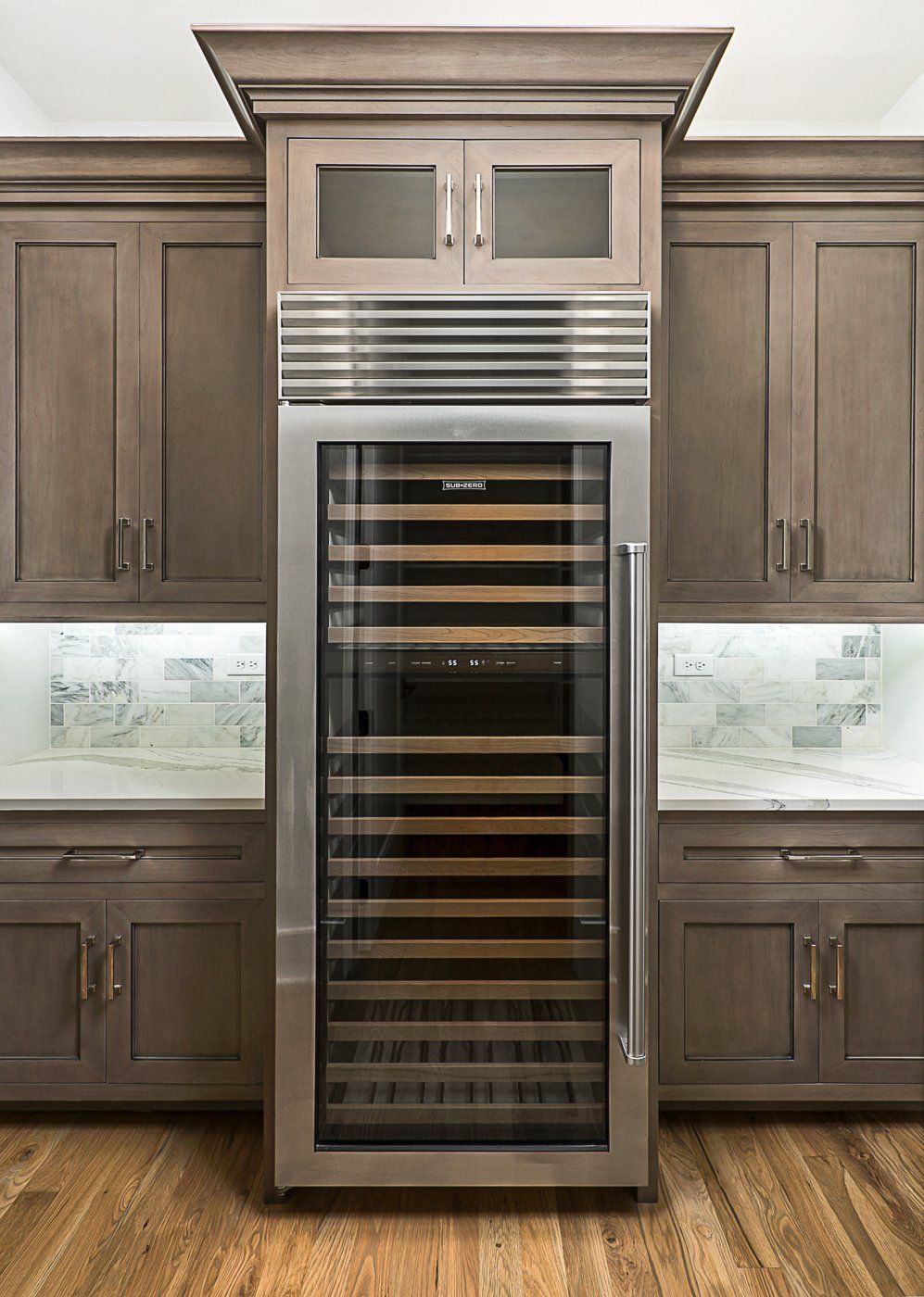 A stainless steel wine cooler is built into the wall of a kitchen.