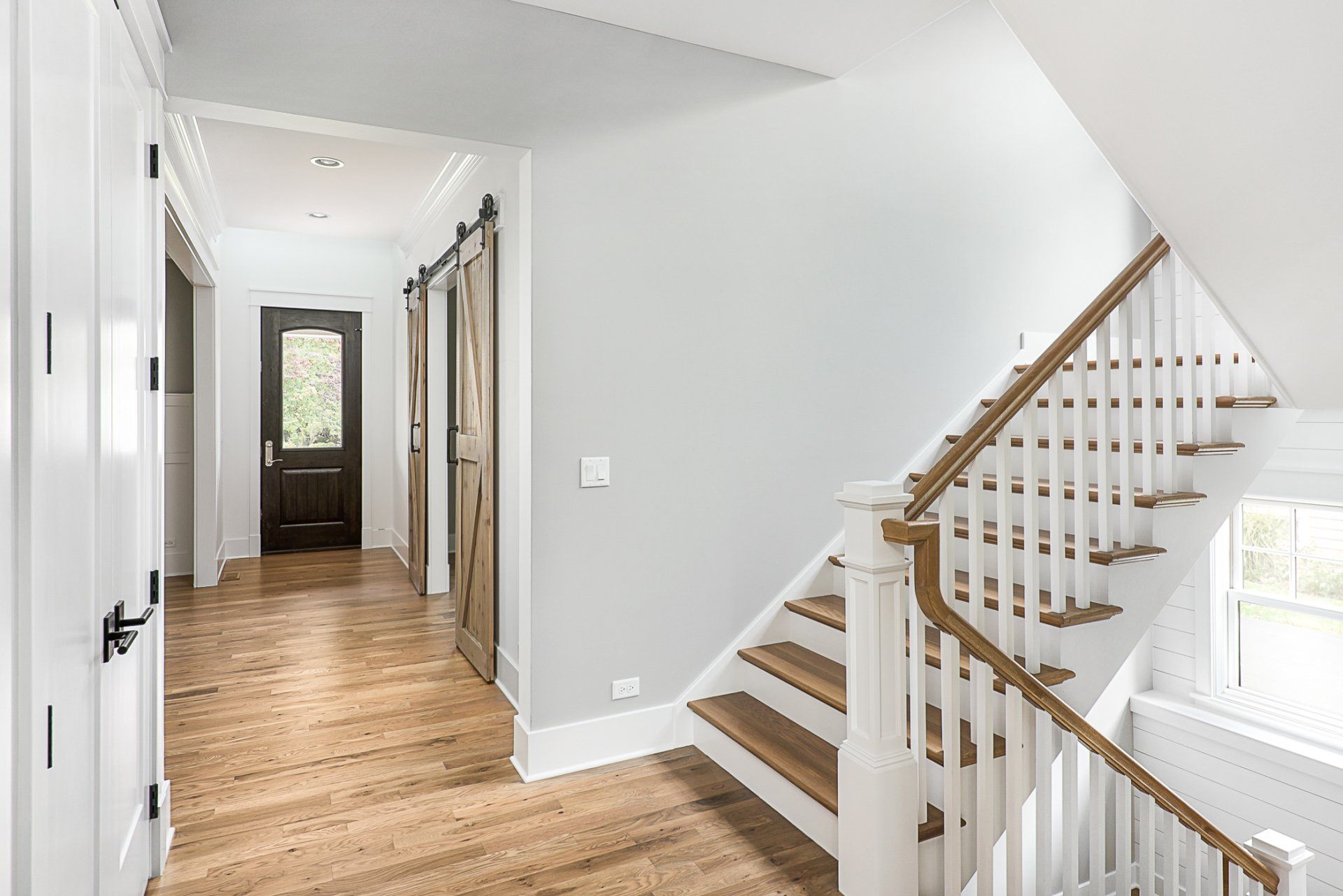 A hallway with a staircase leading up to the second floor of a house.