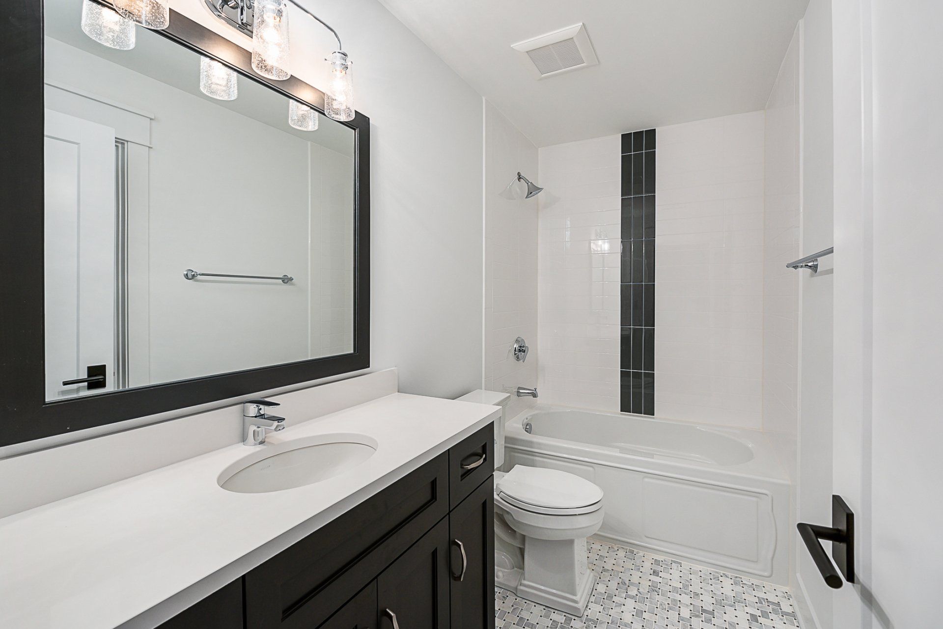 A bathroom with a sink , toilet , bathtub and mirror.