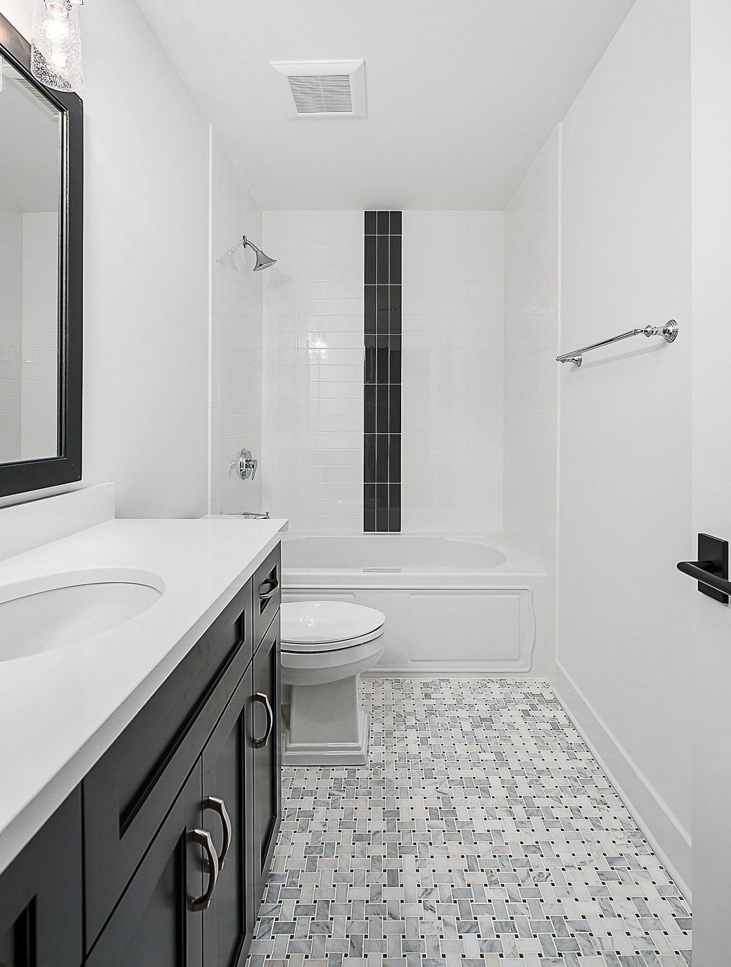 A bathroom with a sink , toilet , bathtub and mirror.