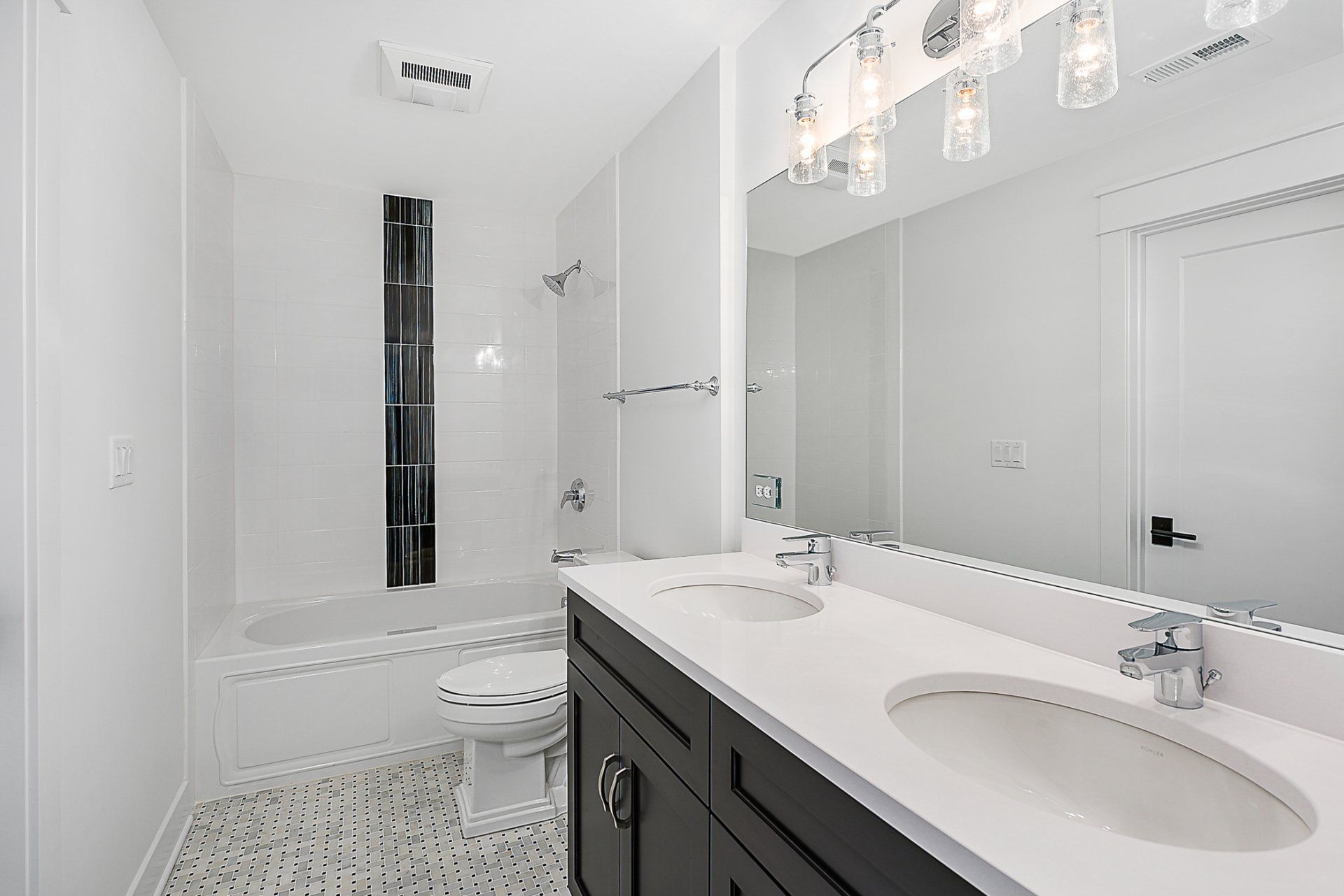 A bathroom with two sinks , a toilet , and a large mirror.
