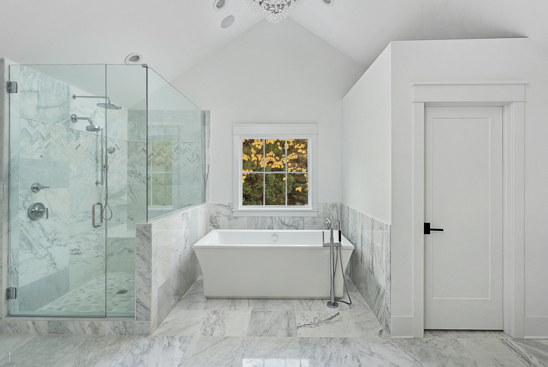 A bathroom with a tub , shower , and window.