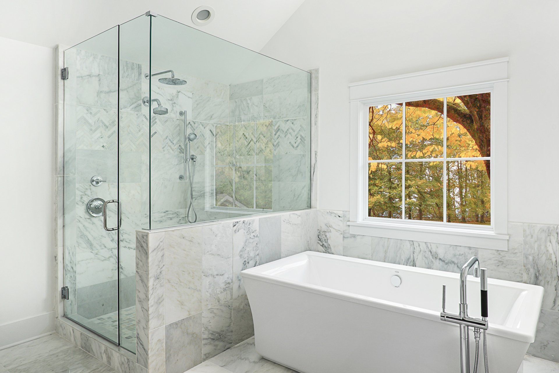 A bathroom with a bathtub , shower , and window.