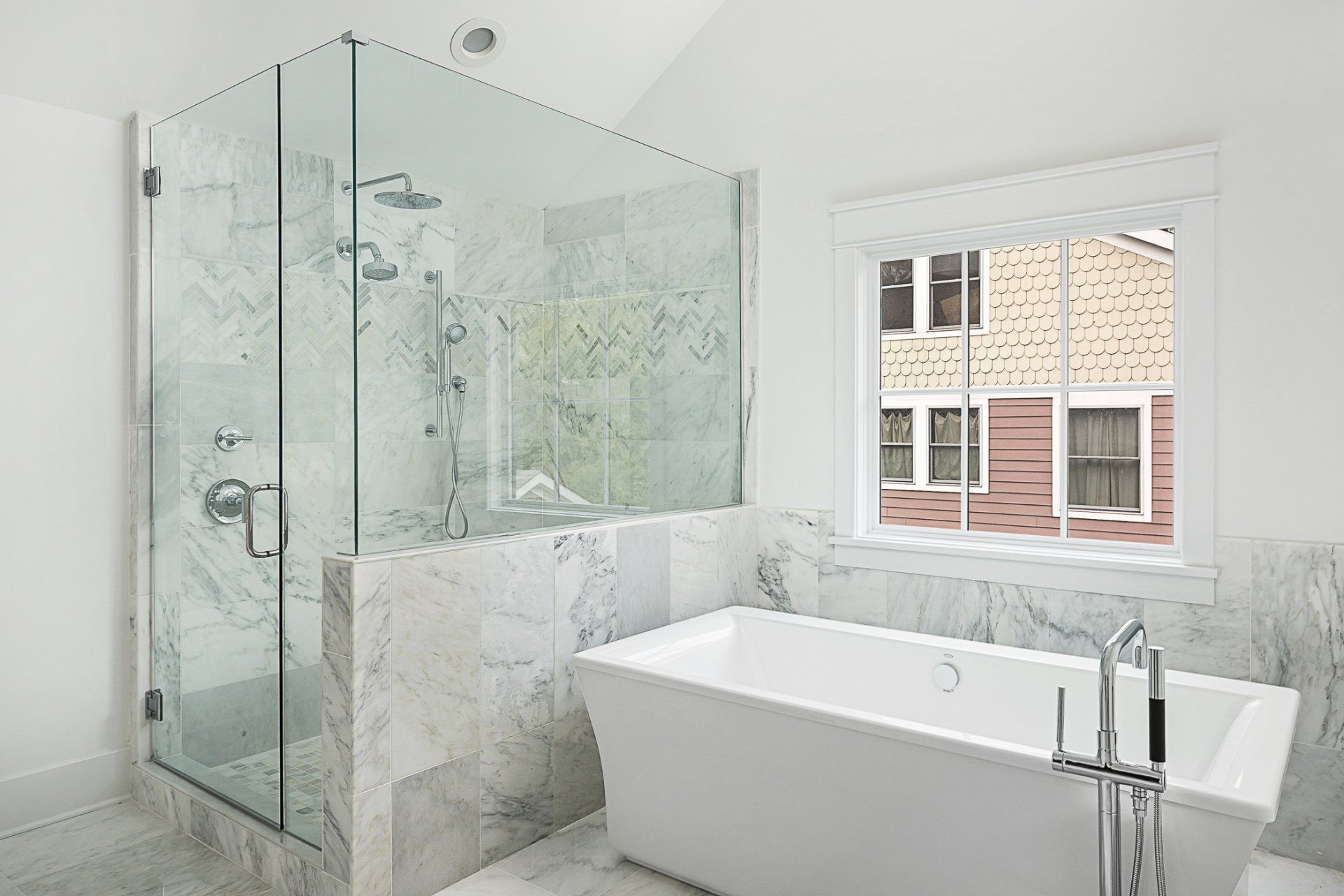 A bathroom with a bathtub , shower , and window.