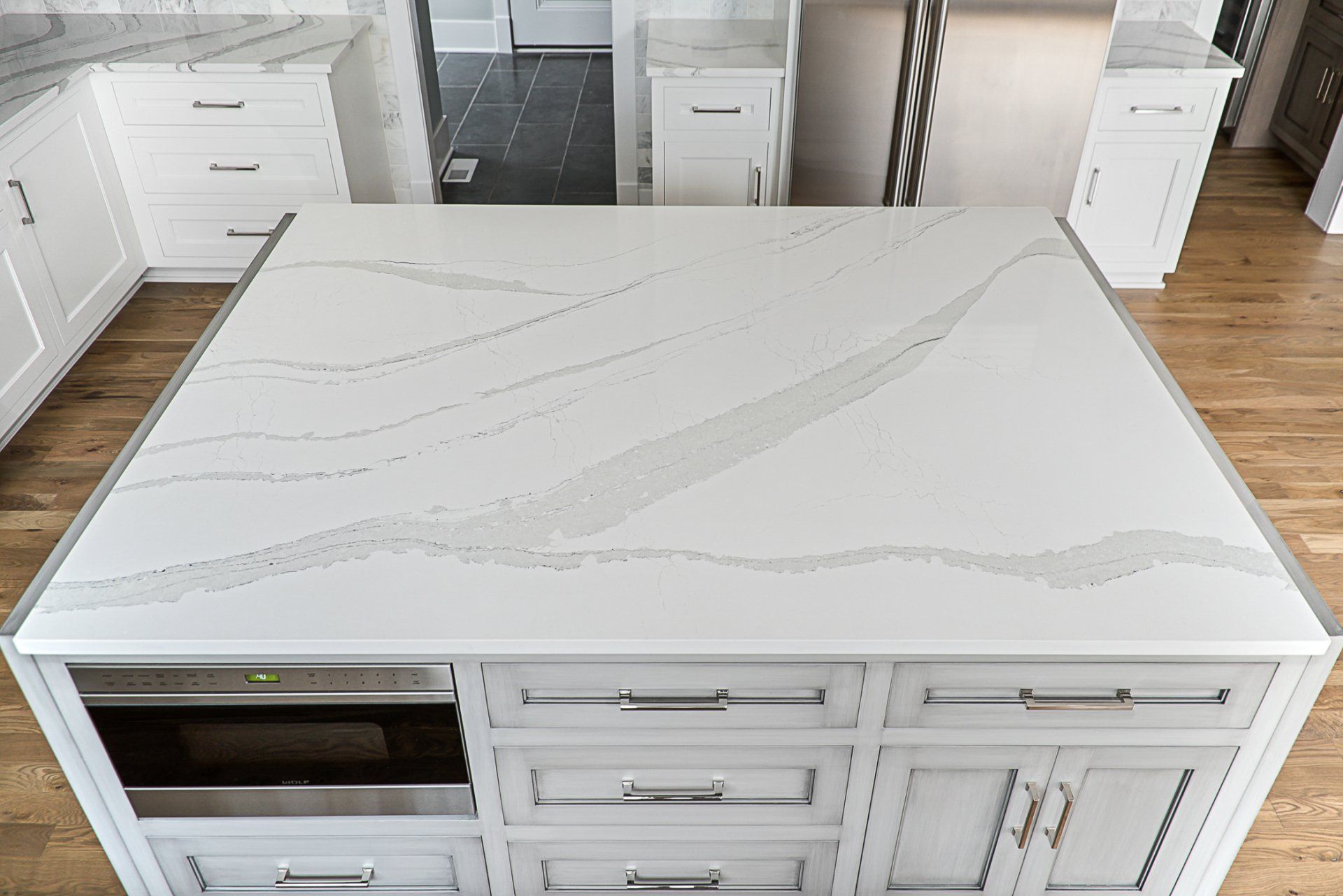 A kitchen with white cabinets and a large white counter top.
