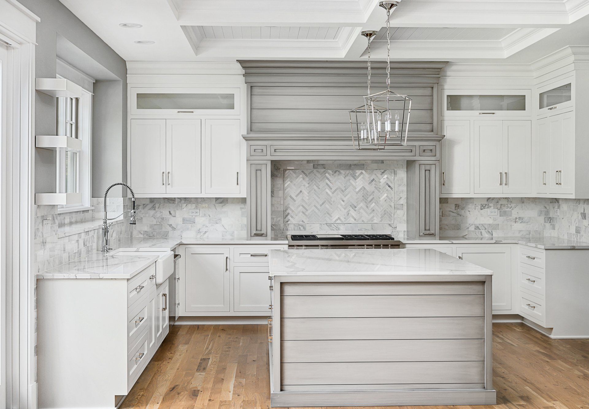 A kitchen with white cabinets and a large island in the middle.
