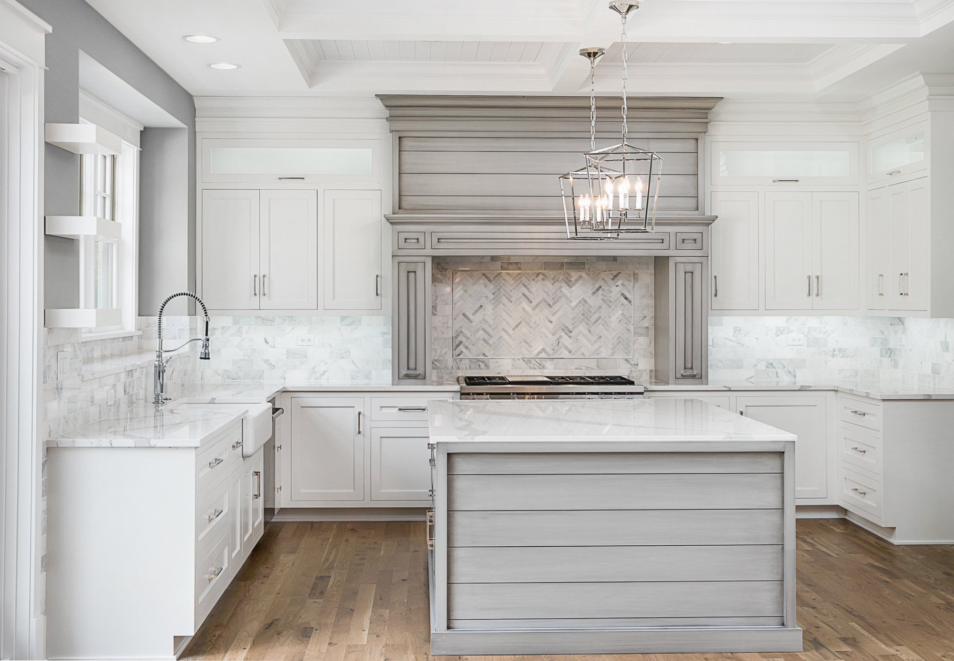 A kitchen with white cabinets and a large island in the middle.