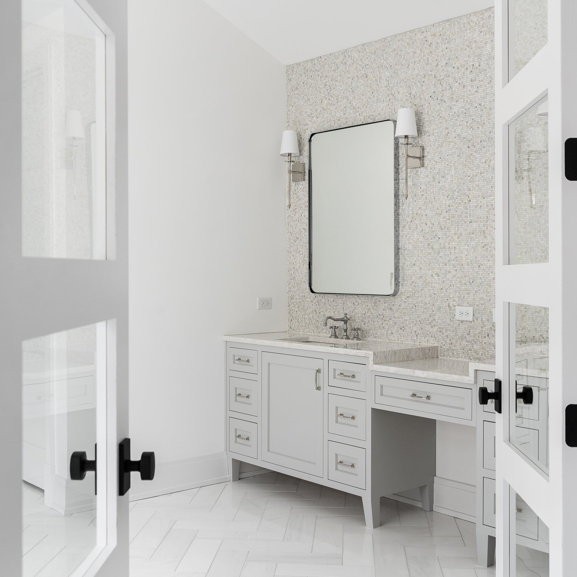 A bathroom with white cabinets and a large mirror