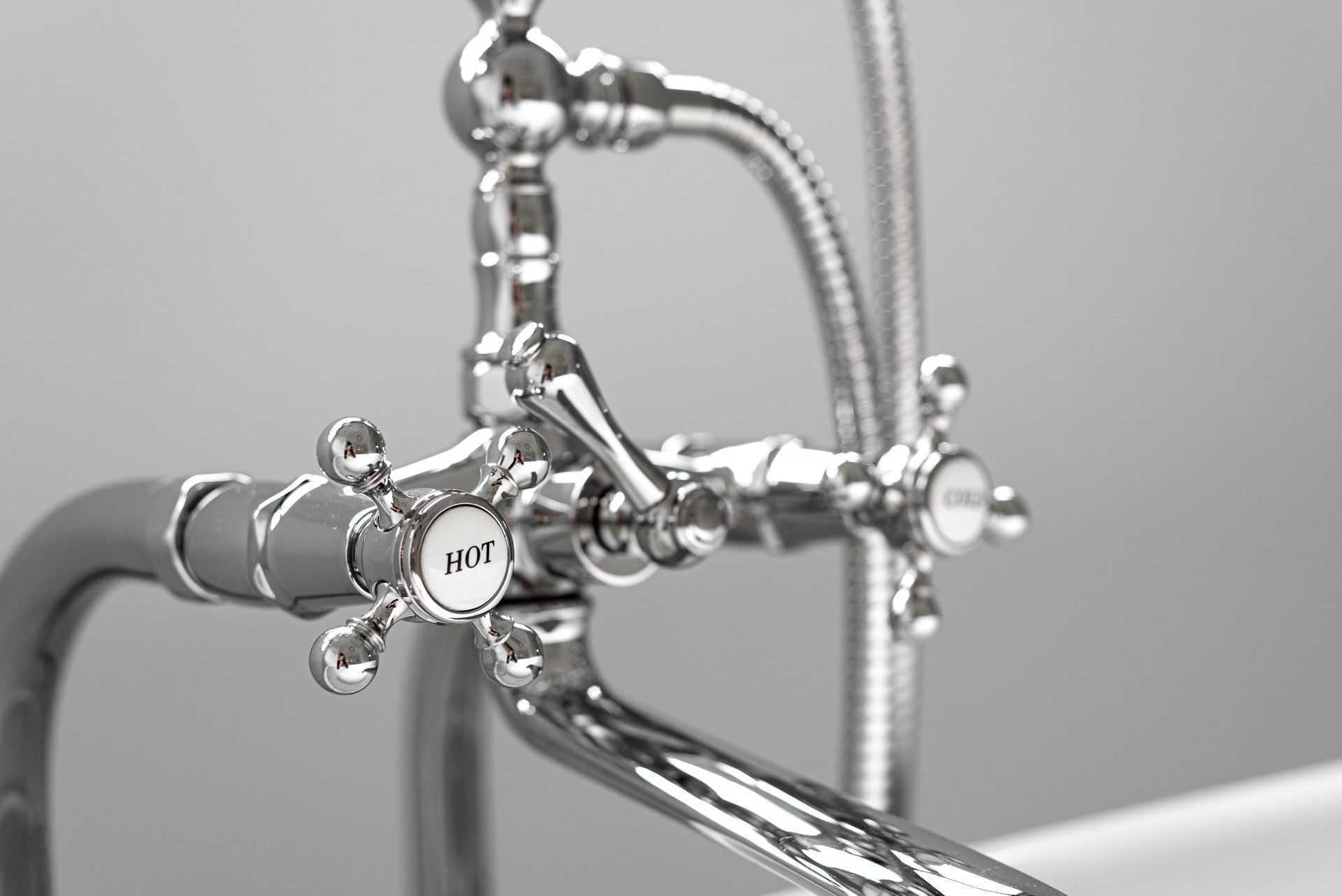 A close up of a bathtub faucet with a shower head attached to it.