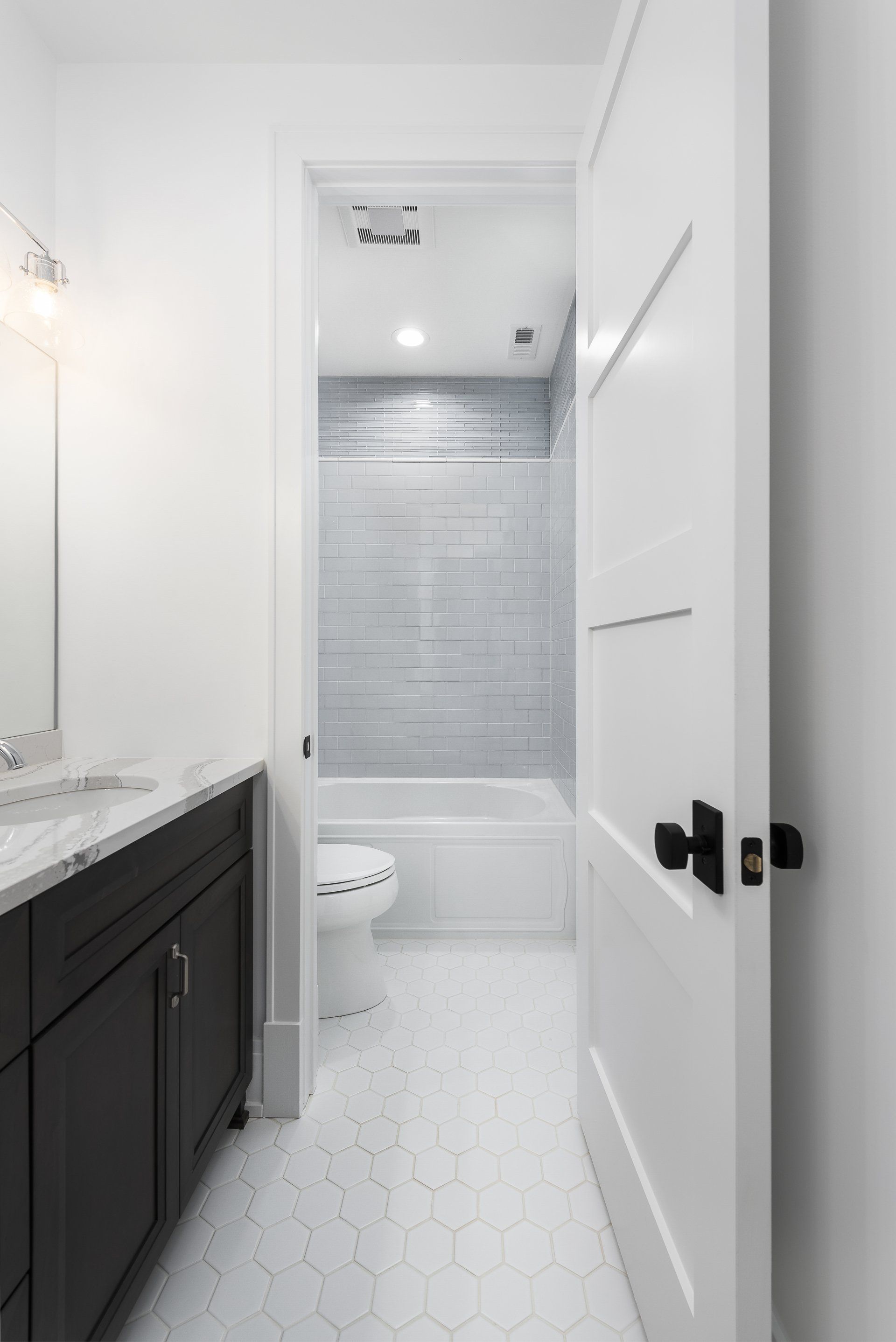 A bathroom with a toilet , sink , and bathtub.