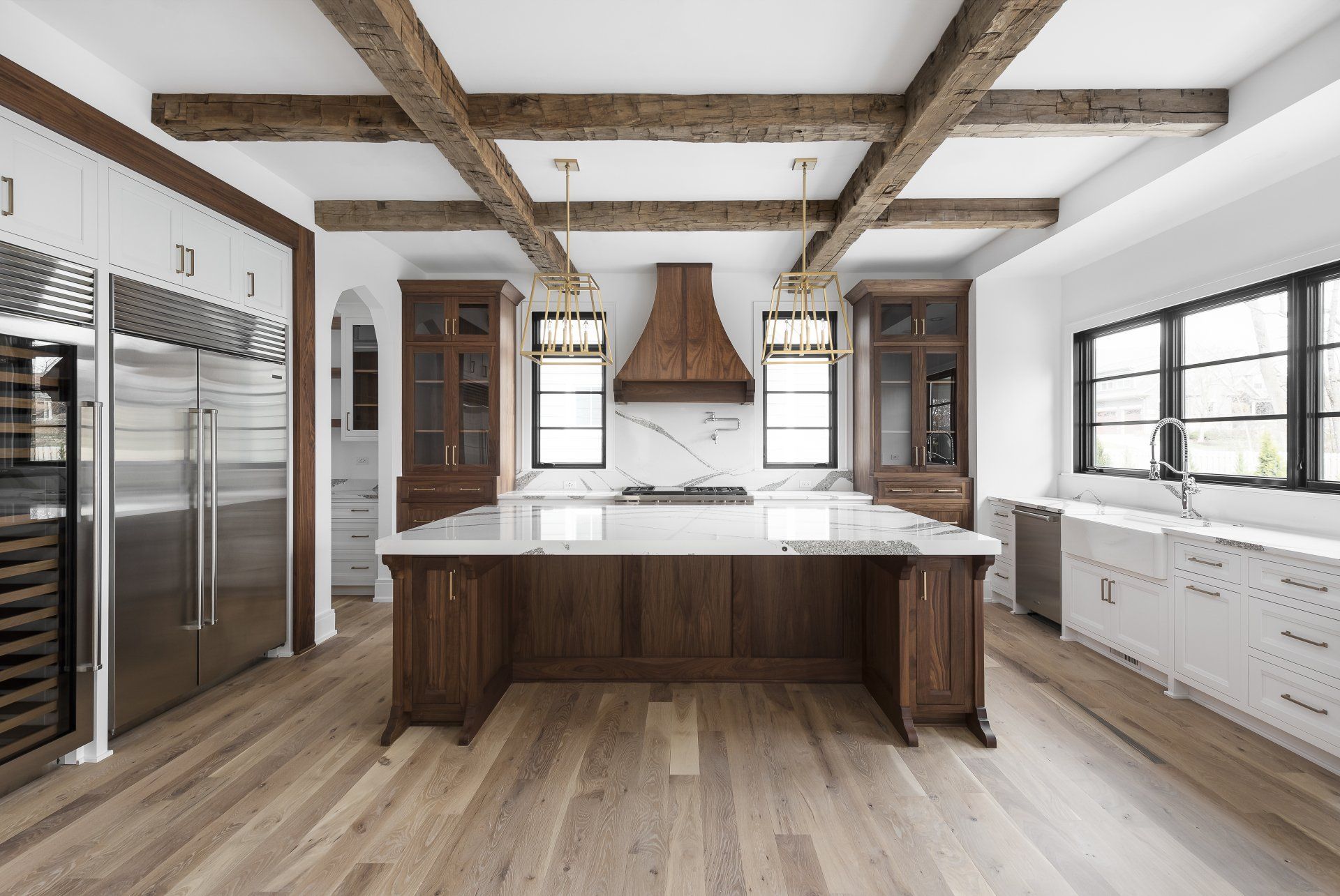 A kitchen with wooden cabinets , stainless steel appliances , and a large island.