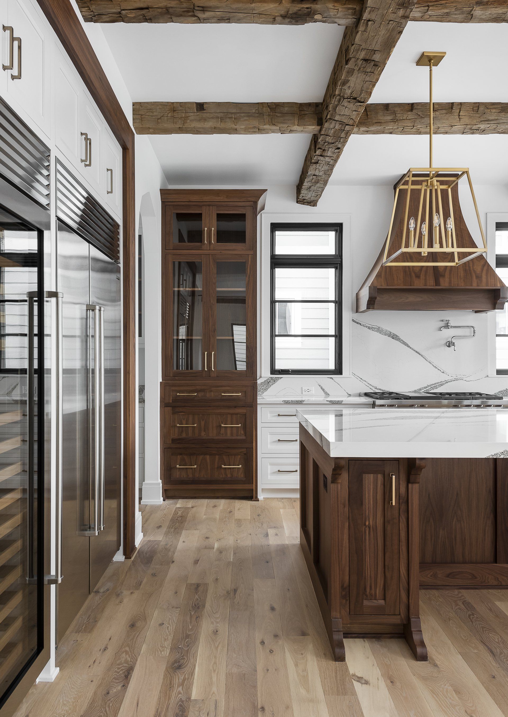 A kitchen with wooden cabinets , stainless steel appliances , and a large island.