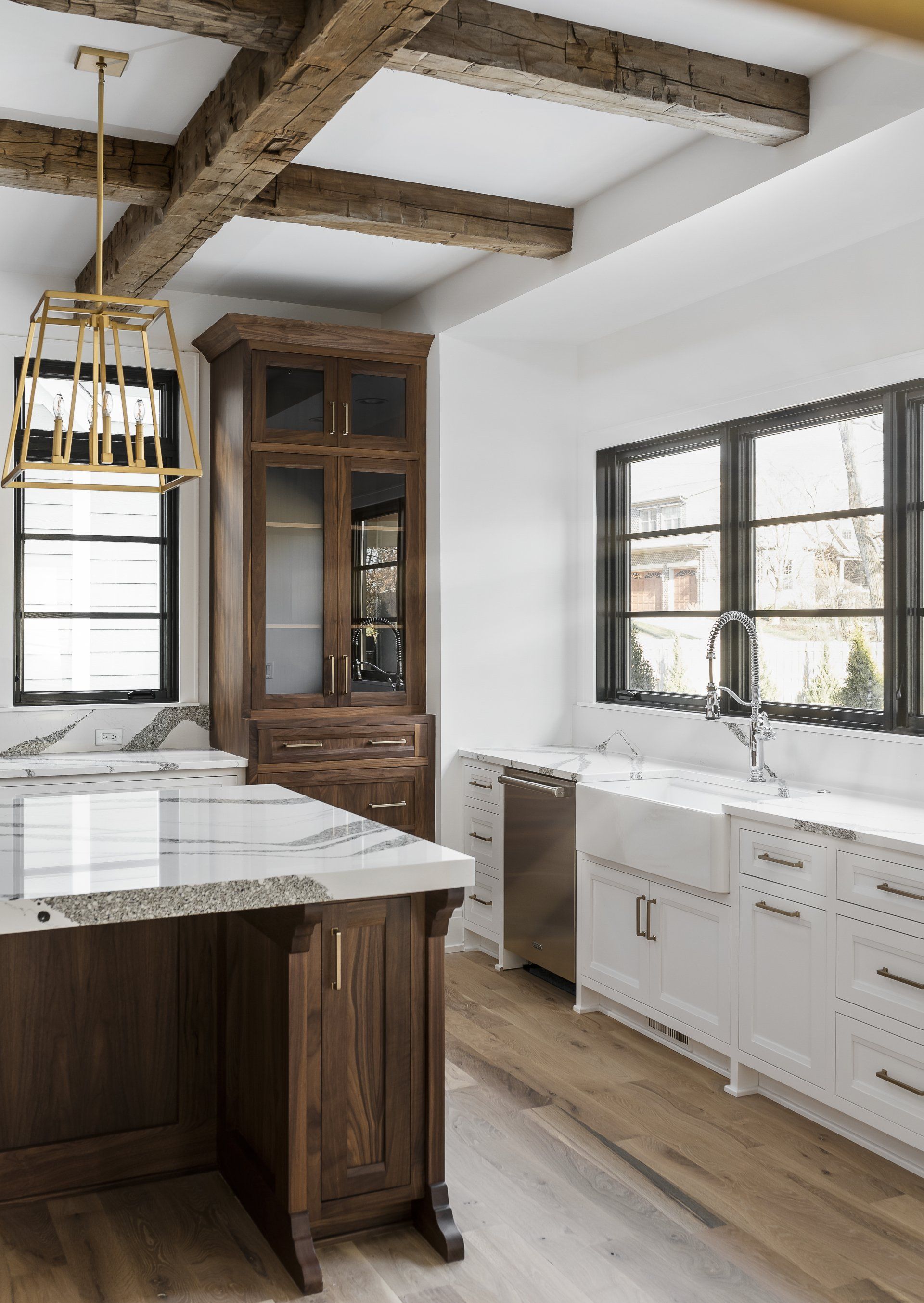 A kitchen with a sink , cabinets , and a large island.