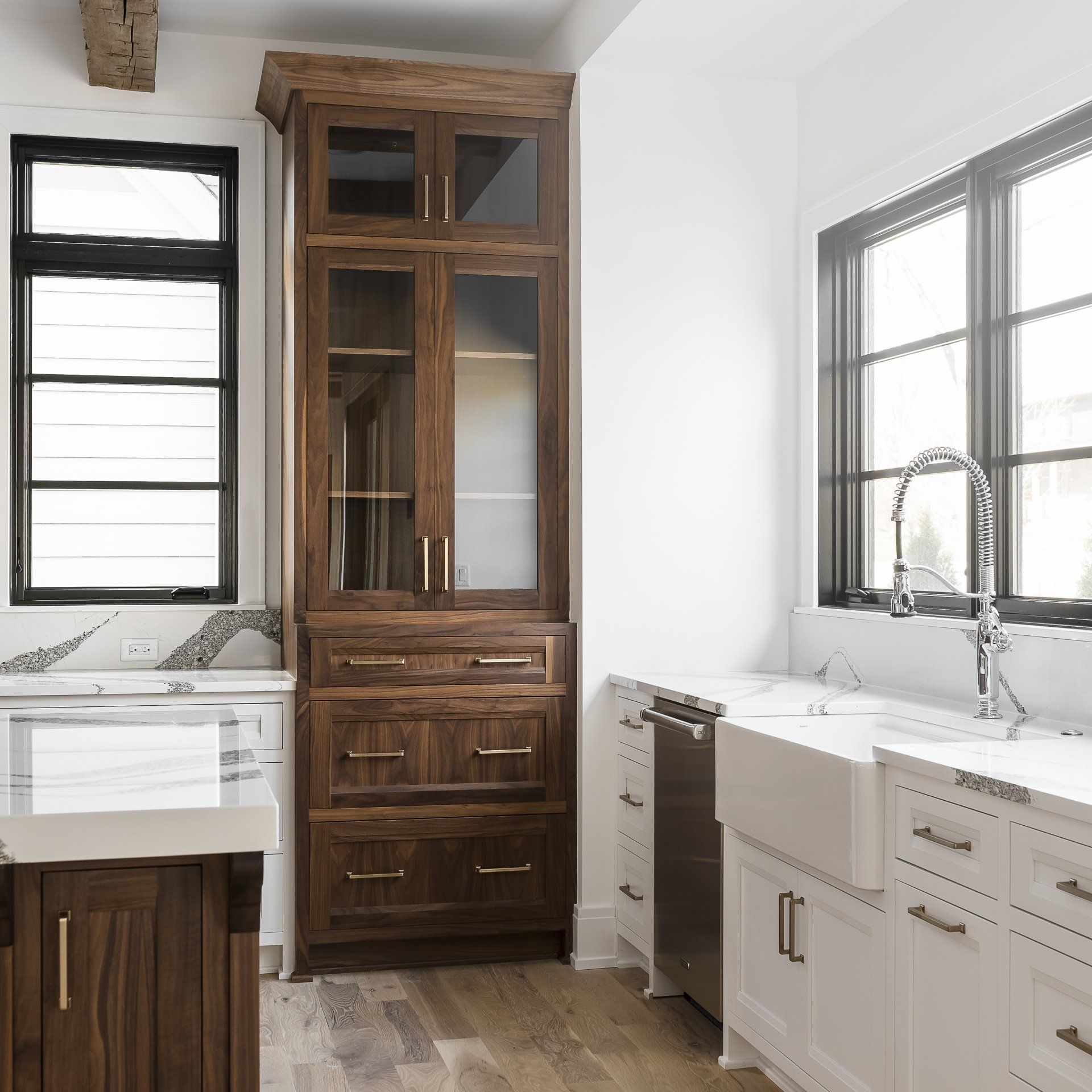 A kitchen with white cabinets , a sink , and a hutch.