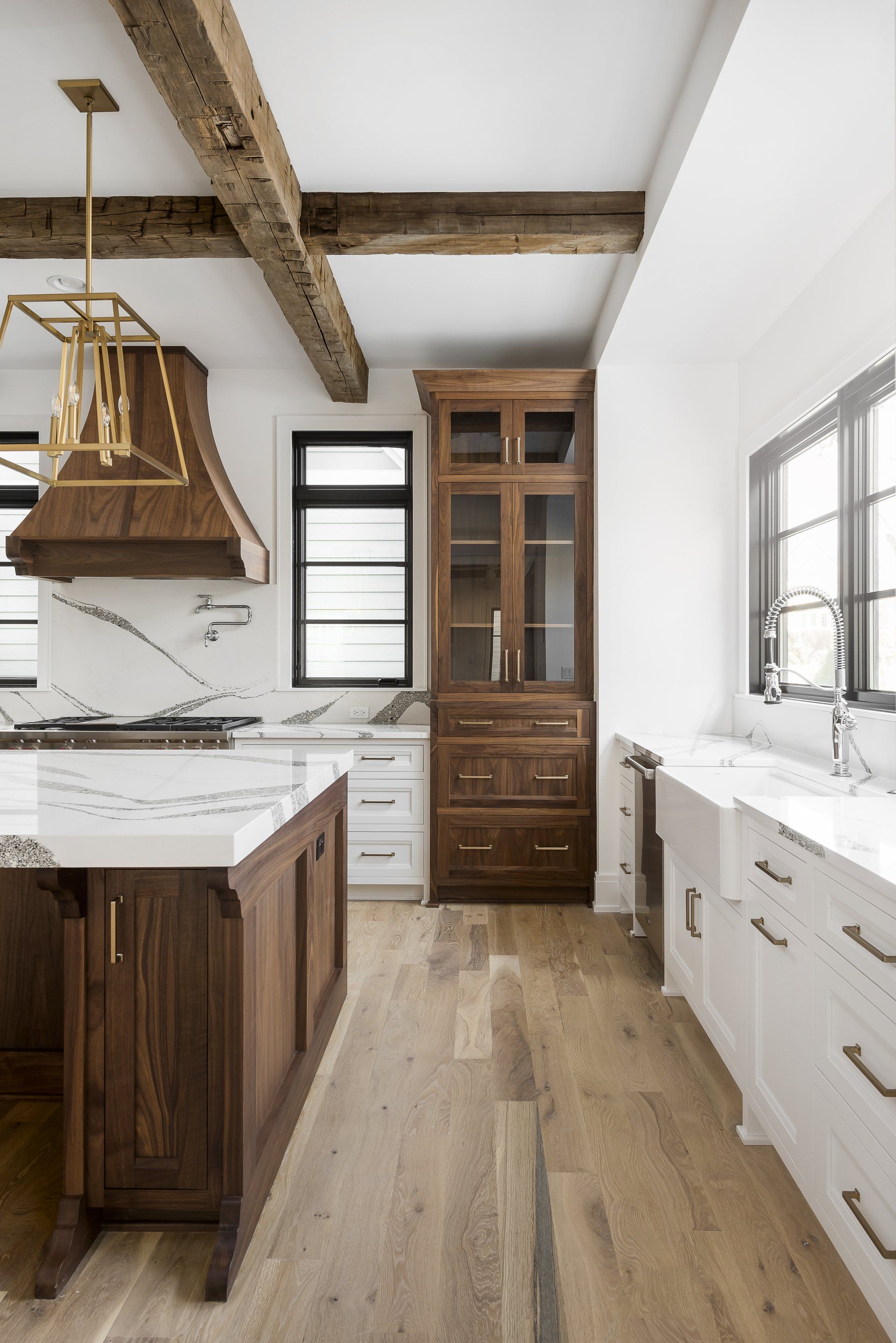 A kitchen with wooden cabinets , white counter tops , a sink and a stove.