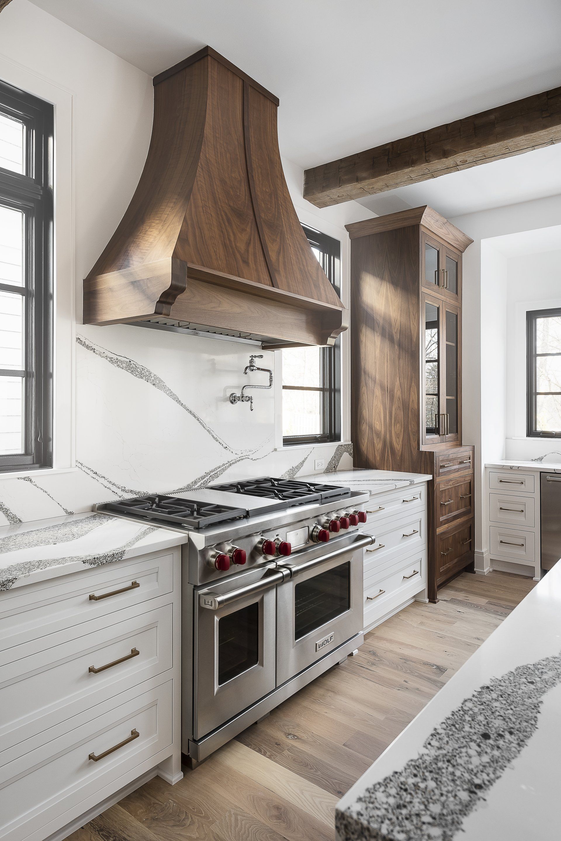 A kitchen with a stove , oven , and hood.