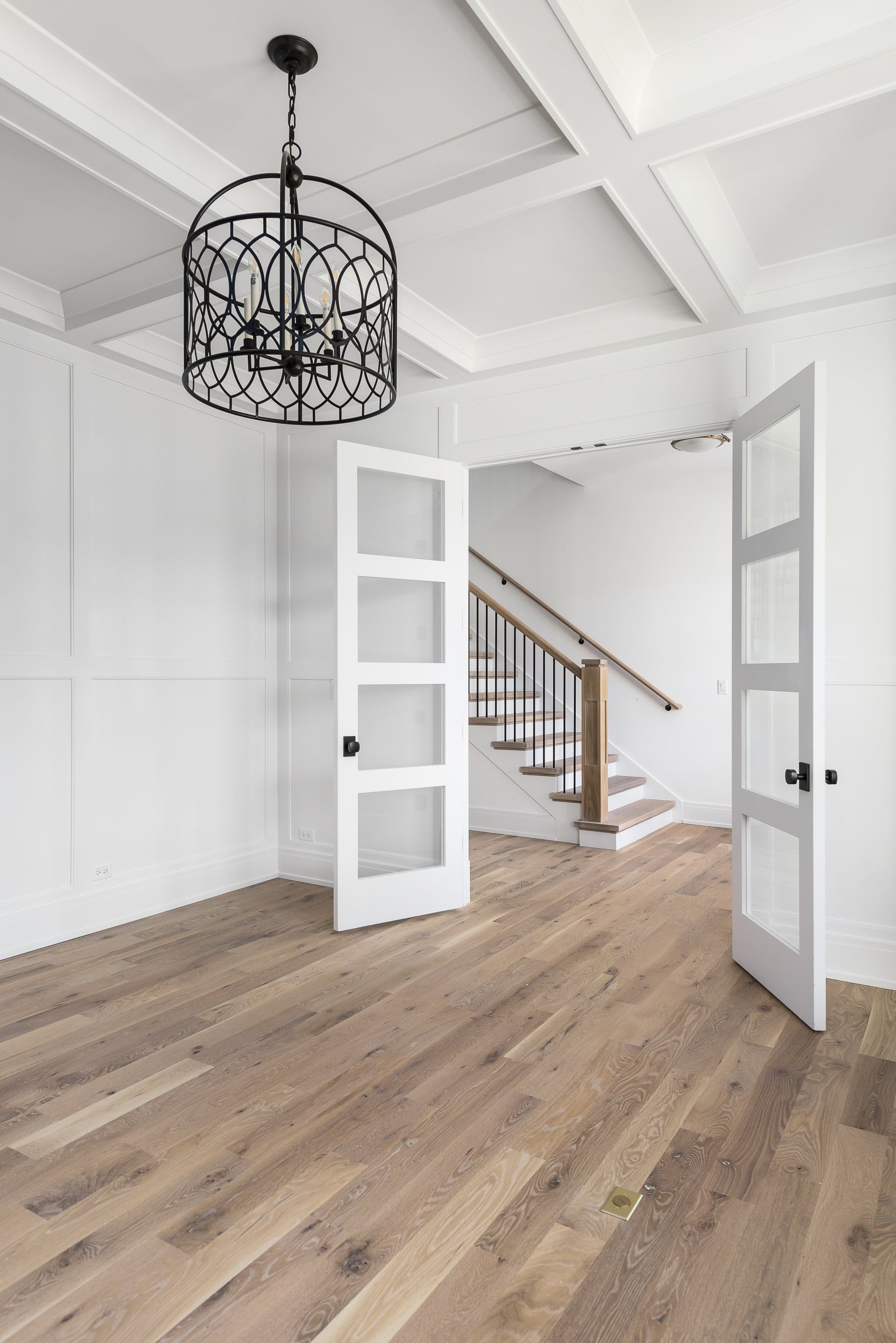 There is a chandelier hanging from the ceiling in the middle of the room.