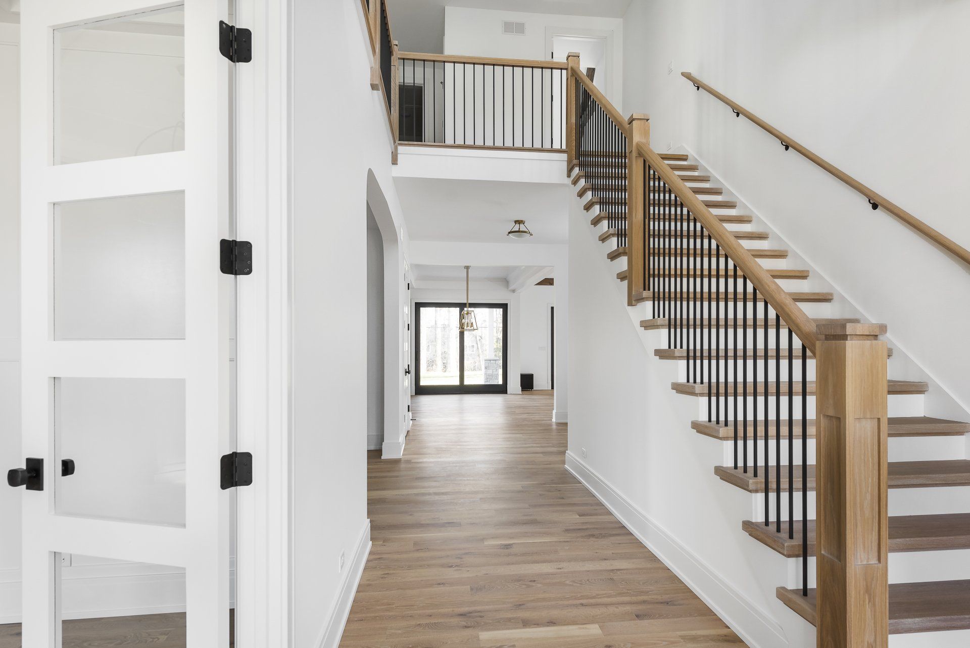 A hallway with stairs leading up to the second floor of a house.