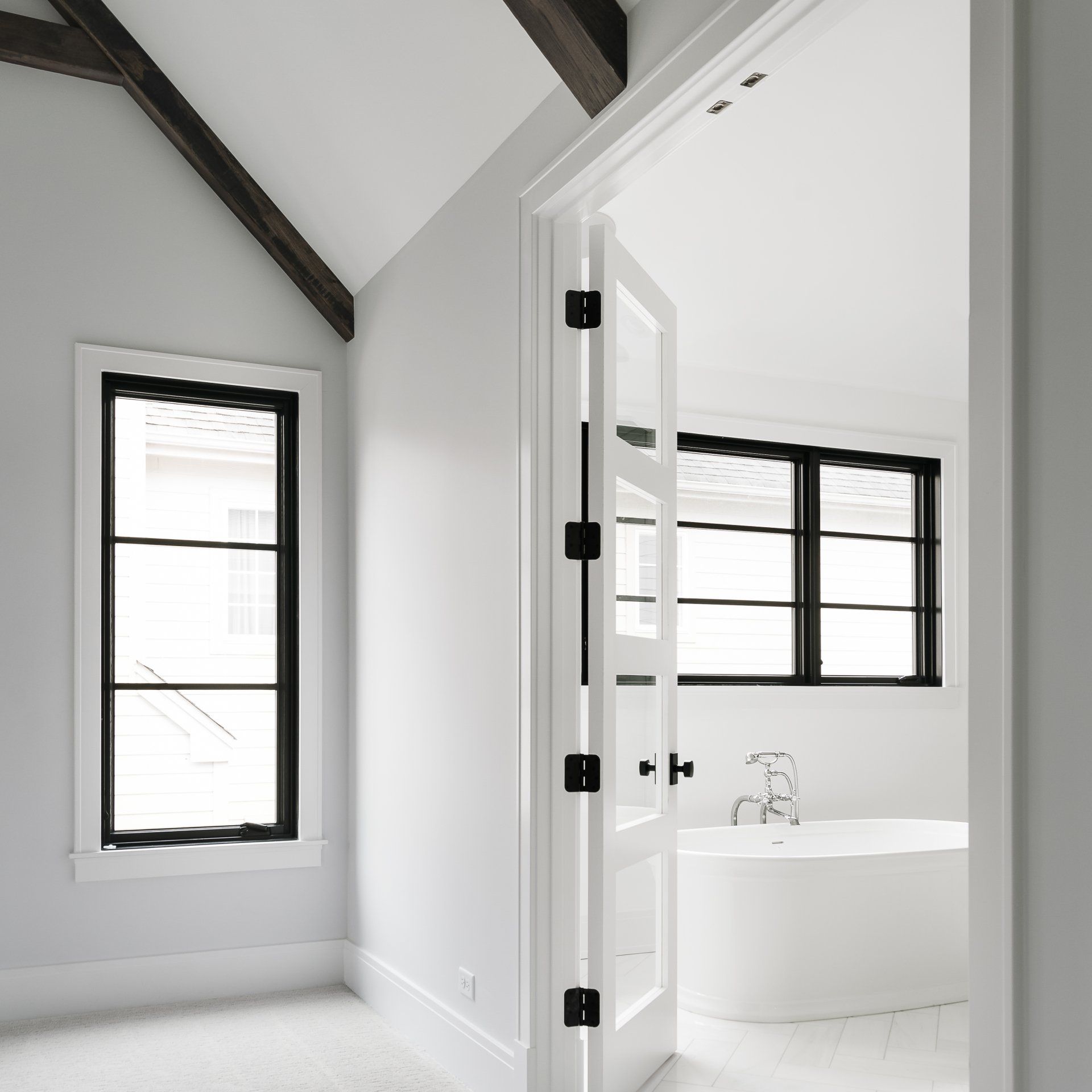 A bathroom with a bathtub and two windows