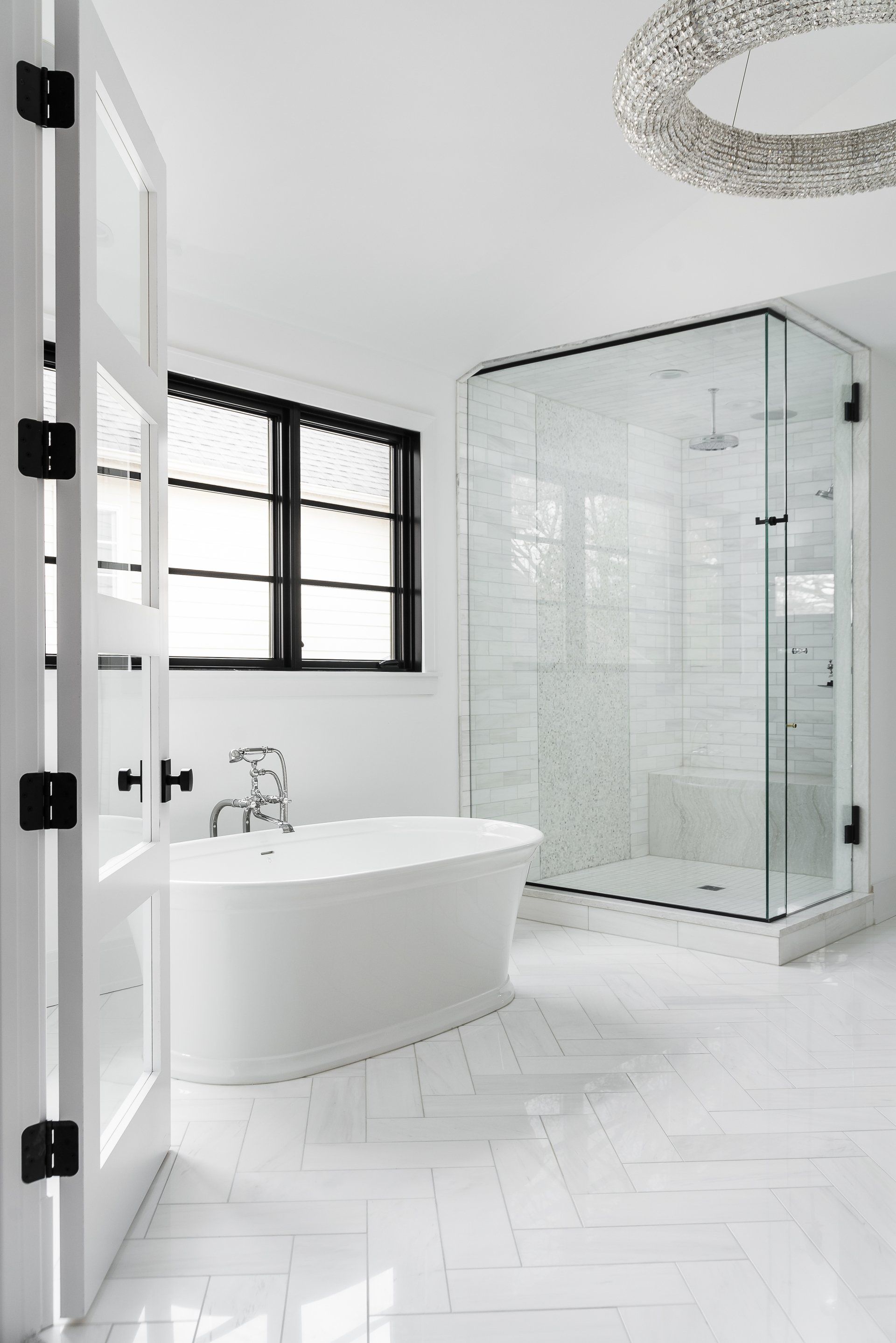A bathroom with a tub , shower , and window.