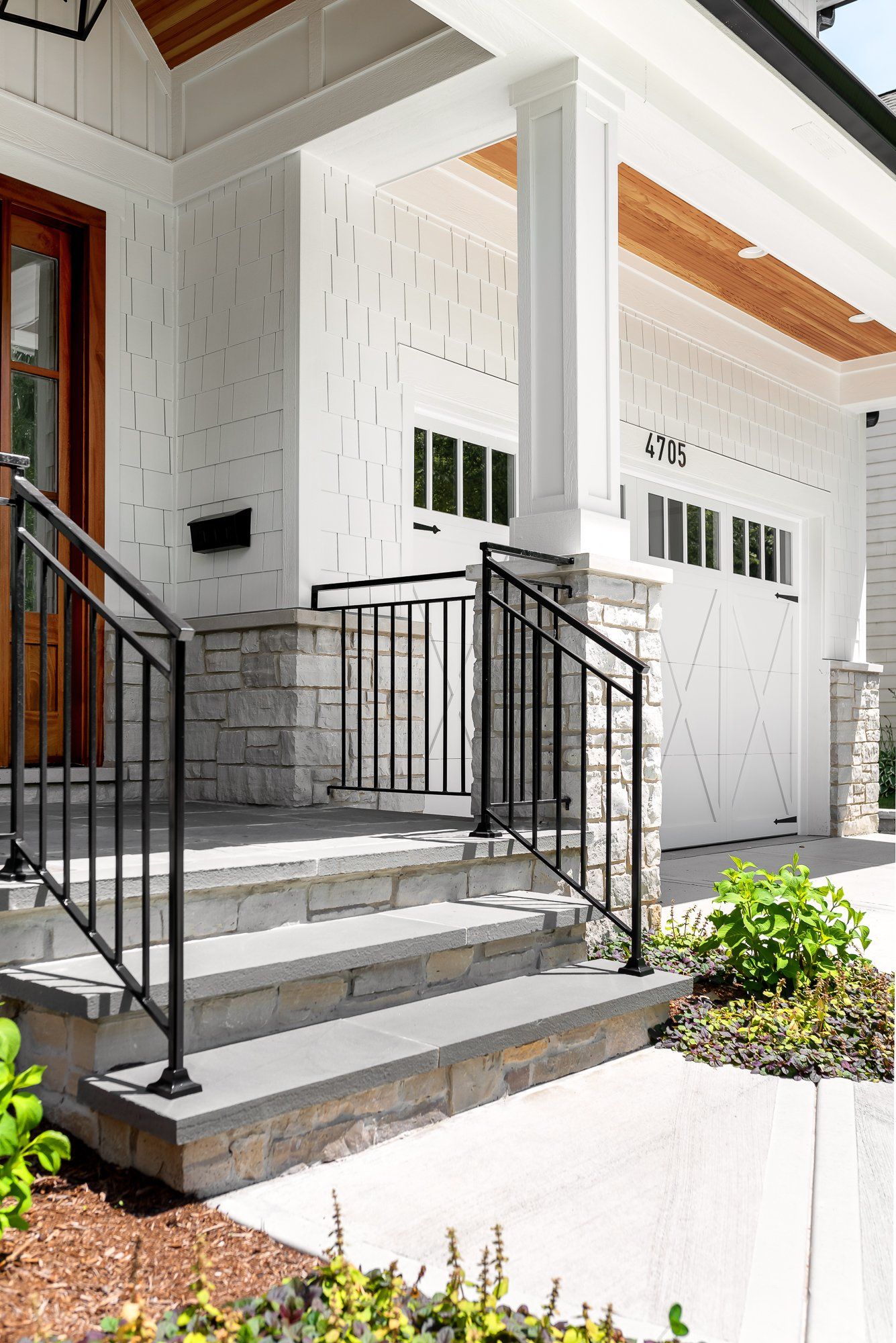 A white house with a black railing and stairs