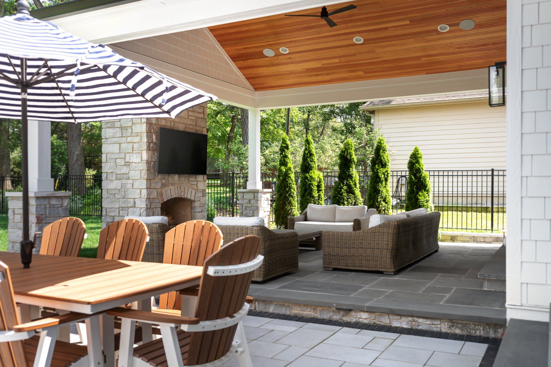 A patio with a table and chairs under an umbrella.