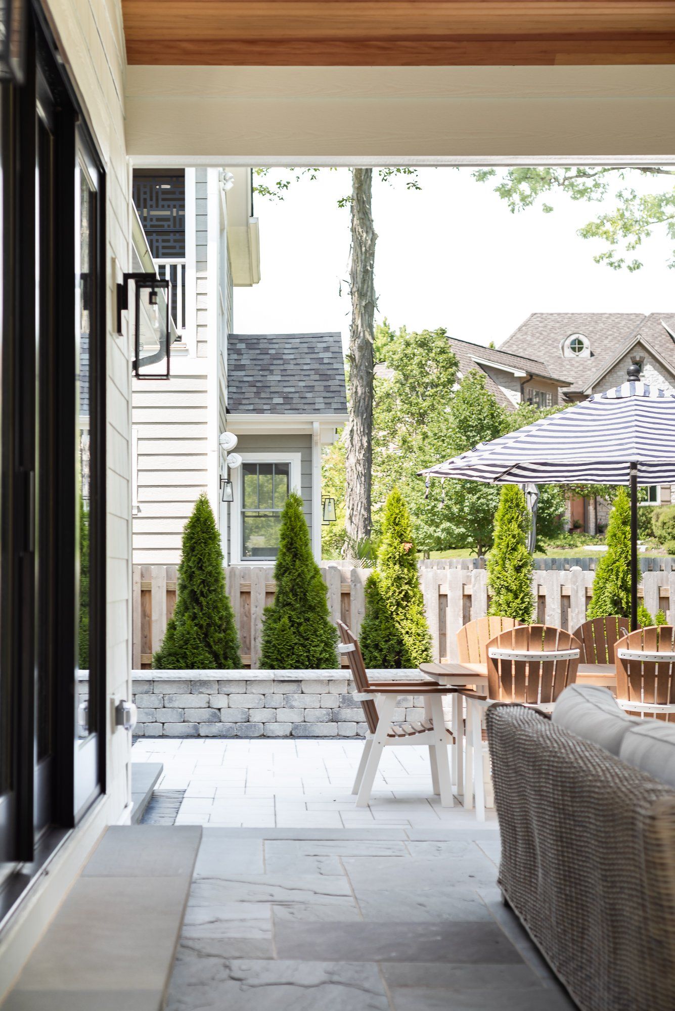 A living room with a couch , chairs , umbrellas and a table.