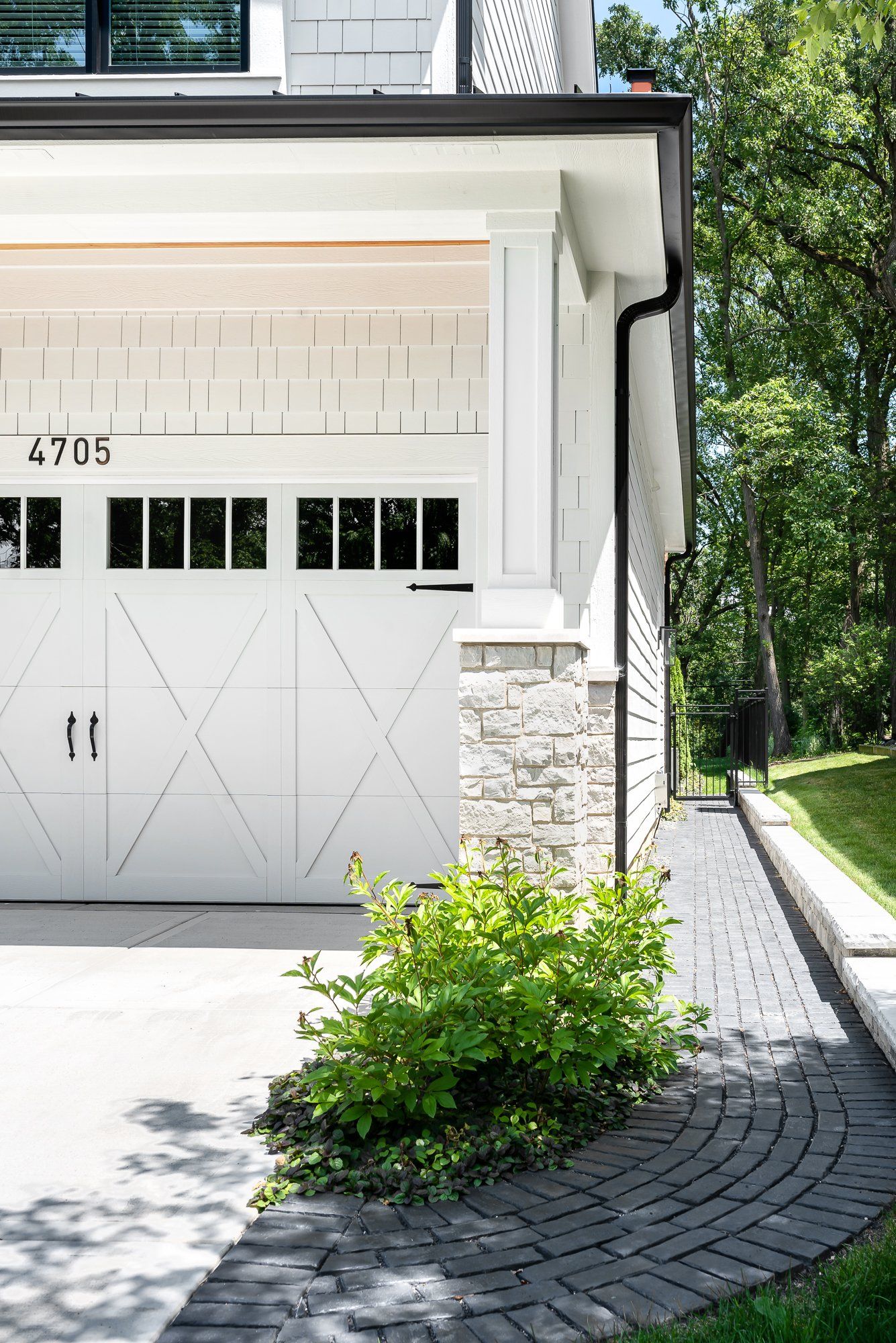 A white garage door is on the side of a house.