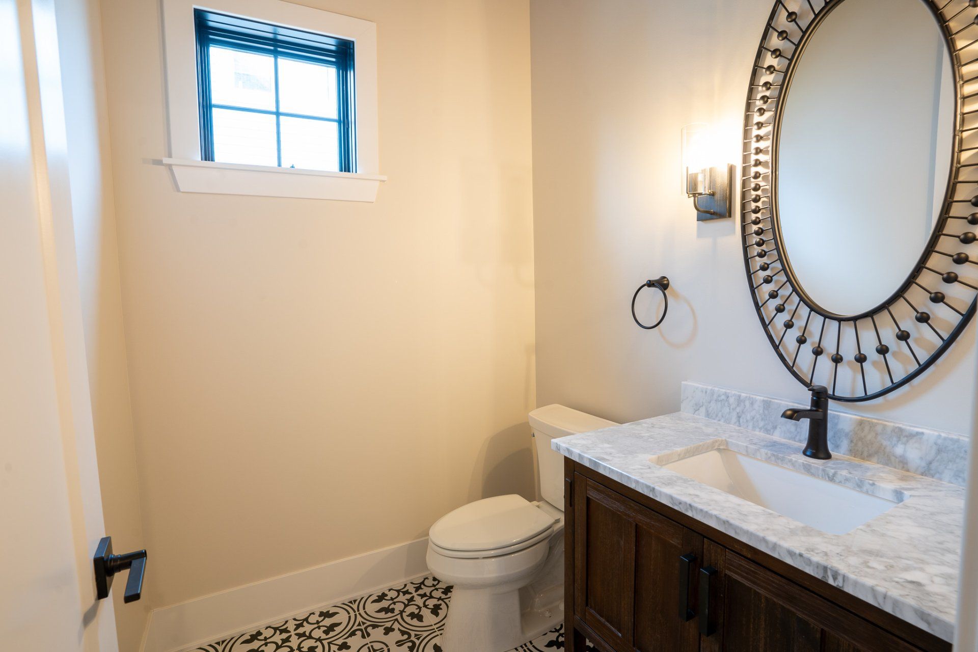 A bathroom with a toilet , sink and mirror.