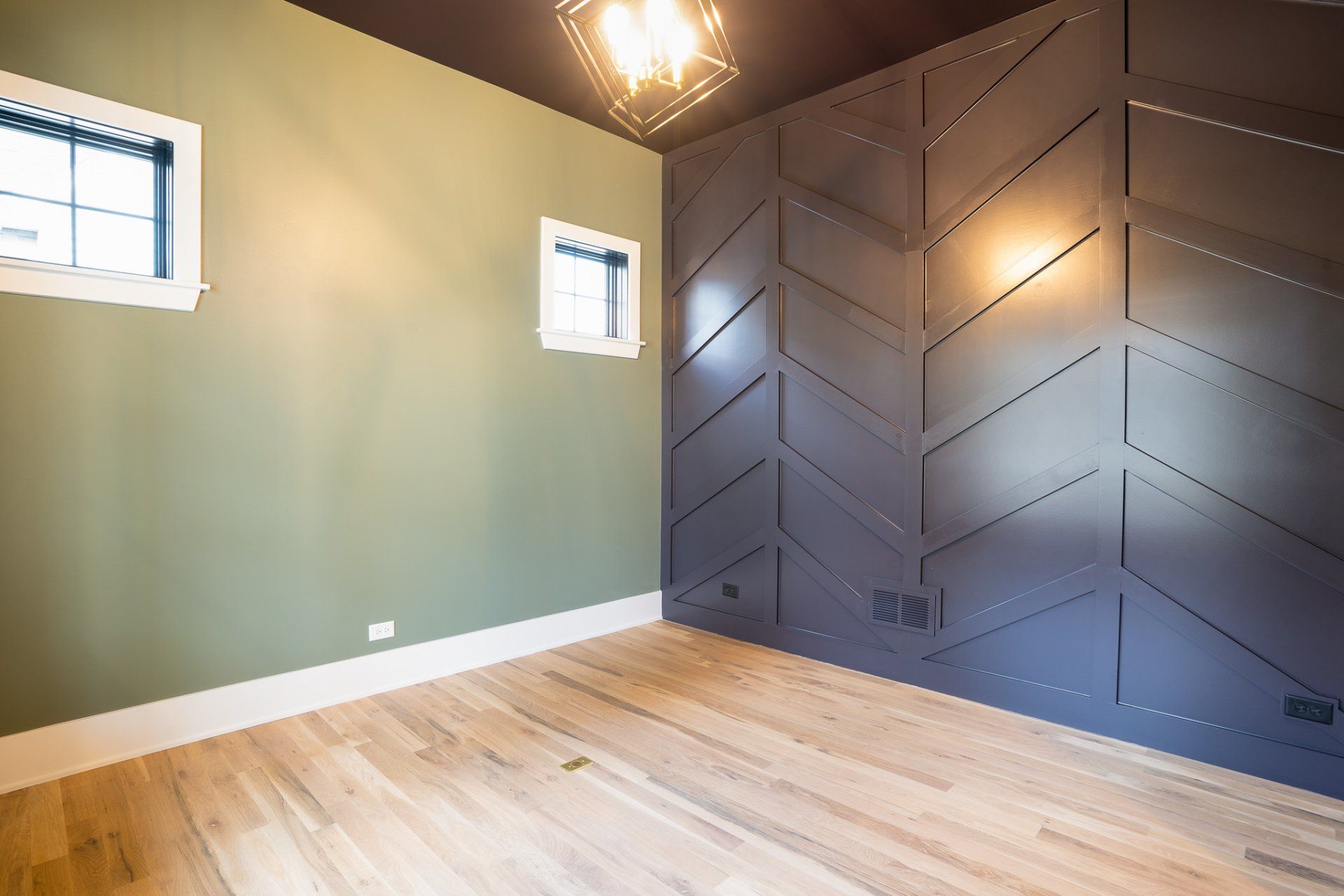 An empty room with green walls and a wooden floor
