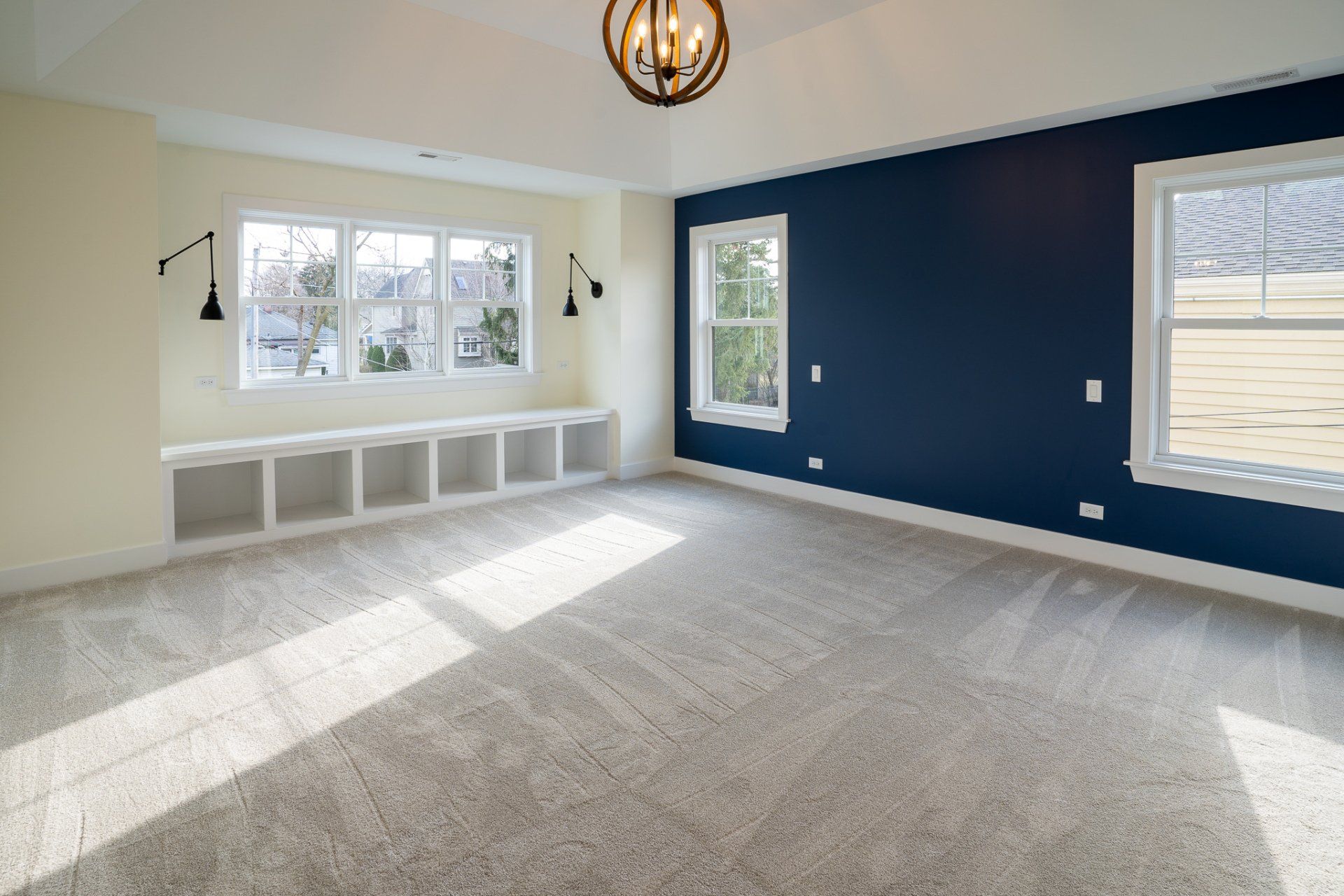 A large empty room with blue walls and a chandelier.