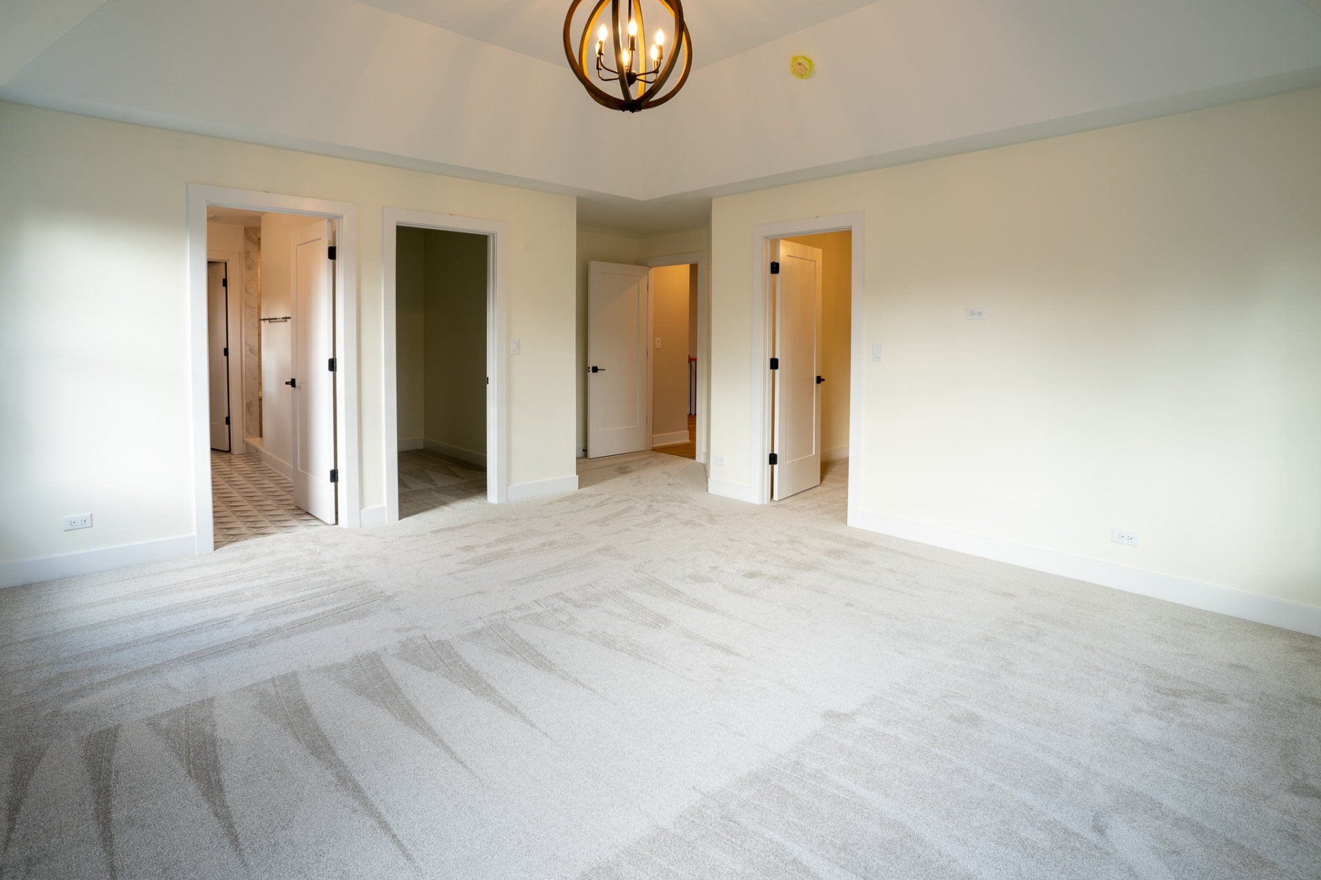 A large empty room with a chandelier hanging from the ceiling.