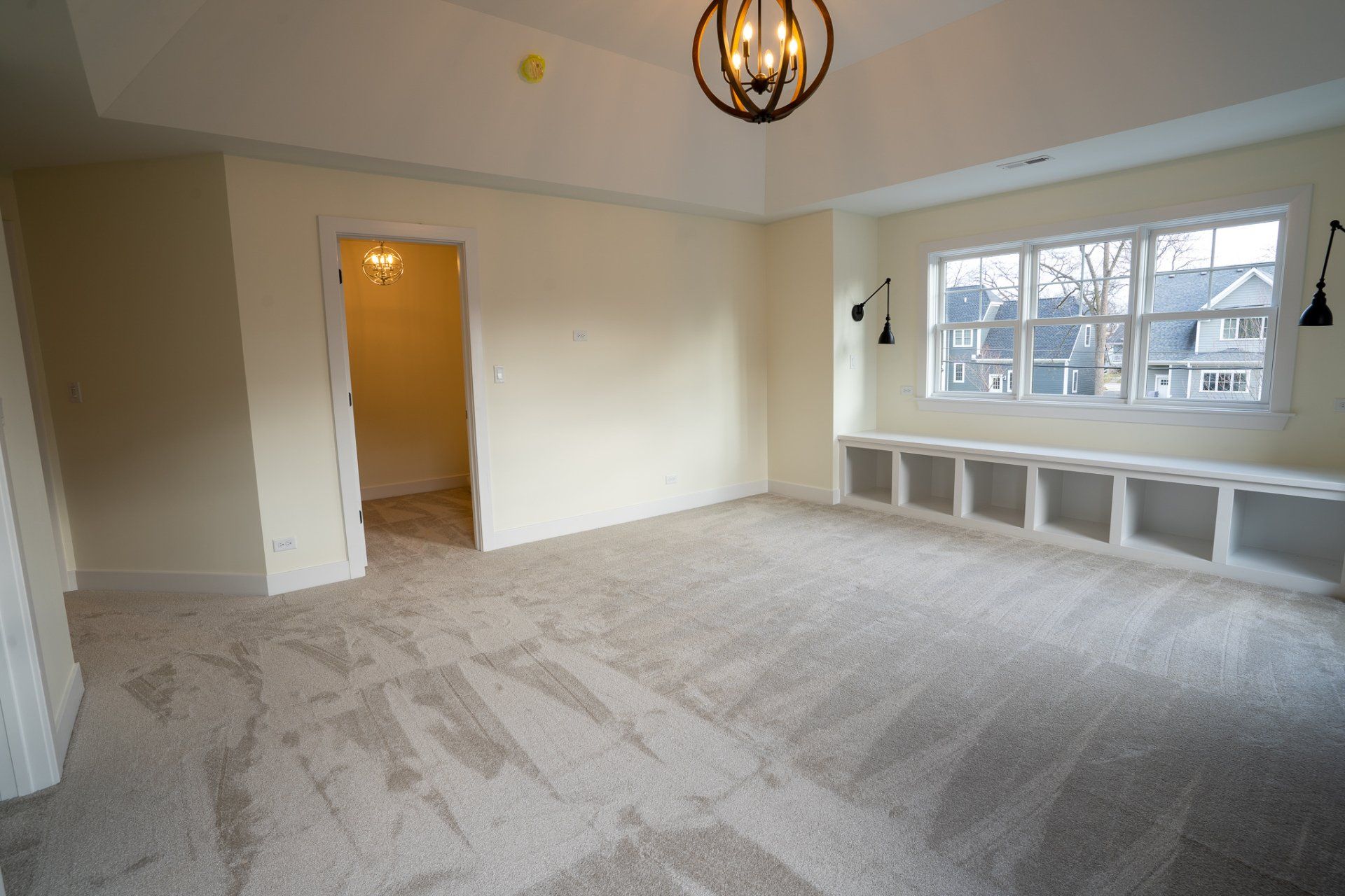 A large empty room with a chandelier hanging from the ceiling.