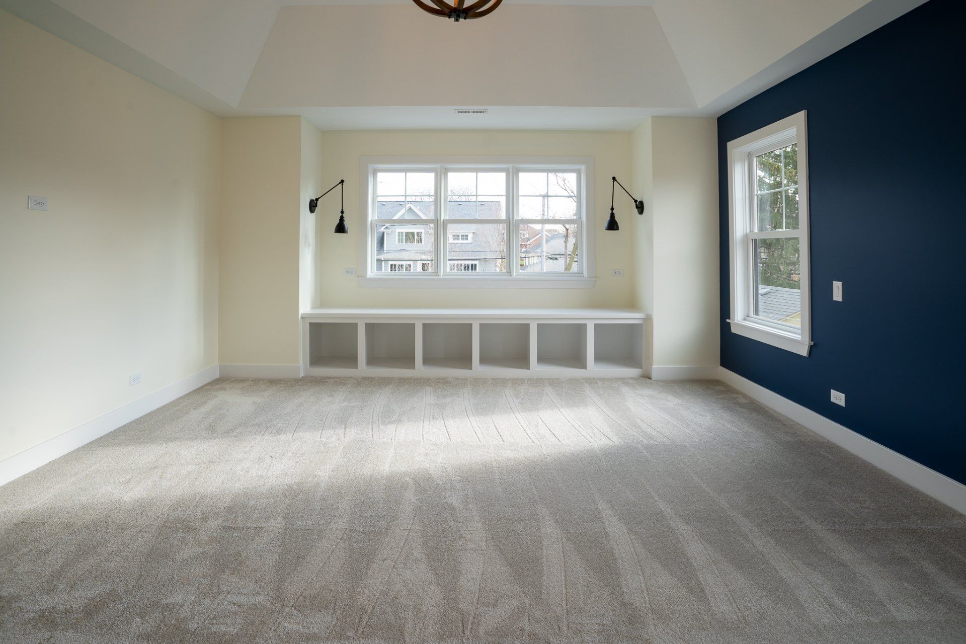 An empty room with blue walls and a window