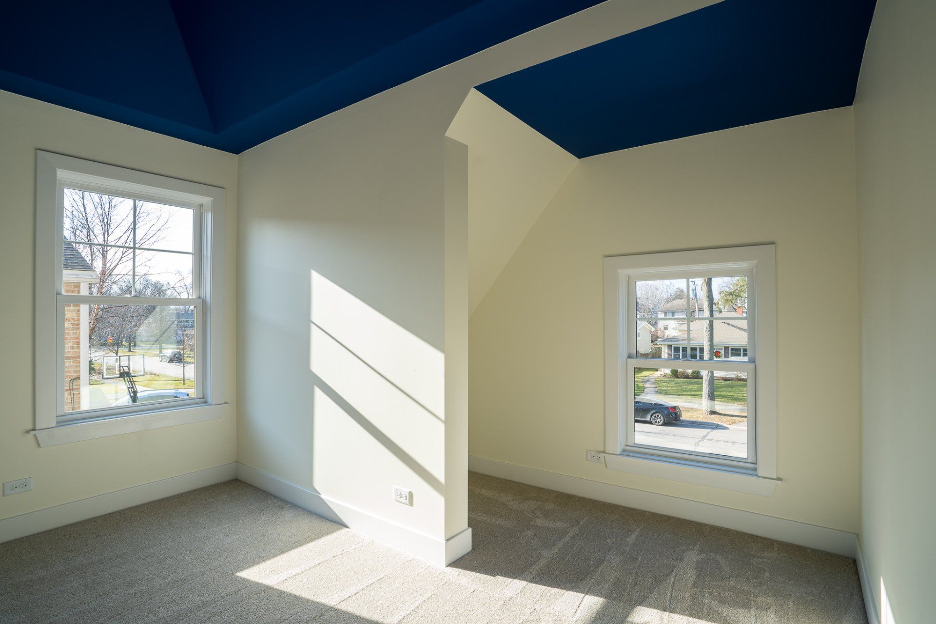 An empty room with a blue ceiling and white walls