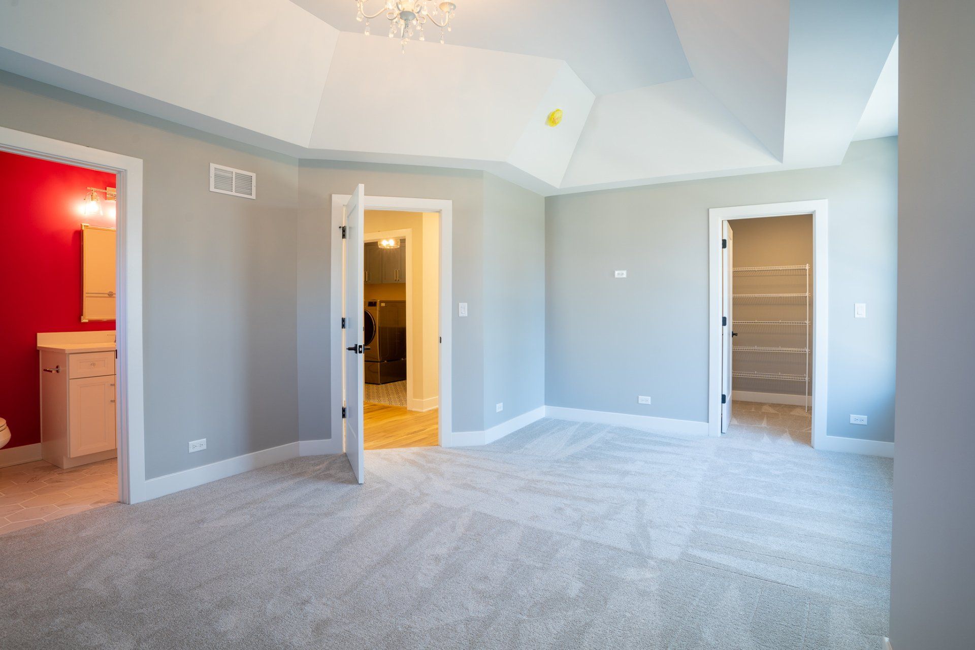 An empty bedroom with a bathroom and a walk in closet.