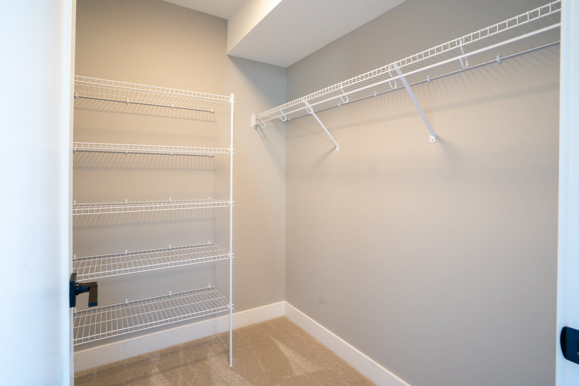 It is a walk in closet with a lot of shelves.