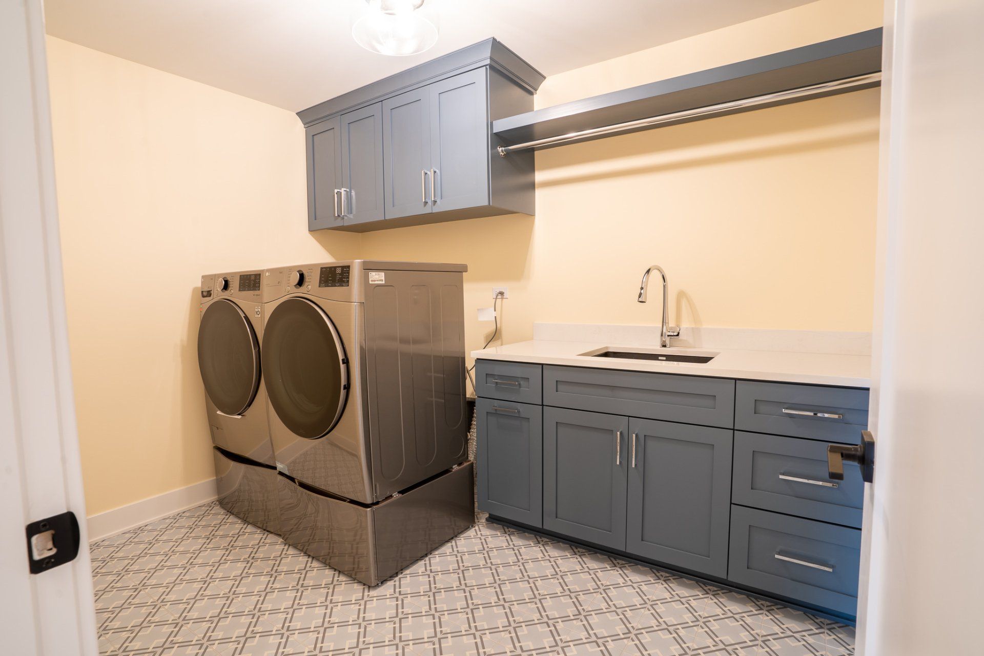 A laundry room with a washer and dryer and a sink.