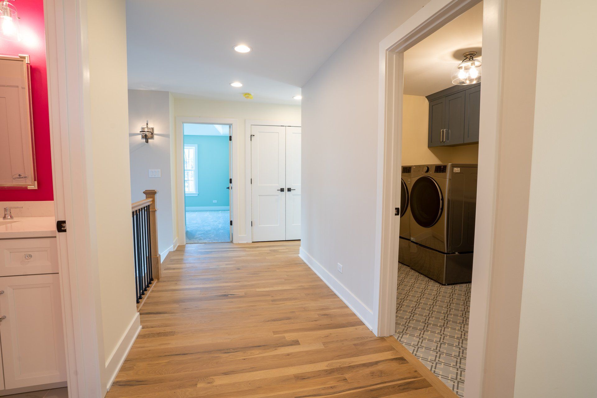 A hallway leading to a laundry room in a house.