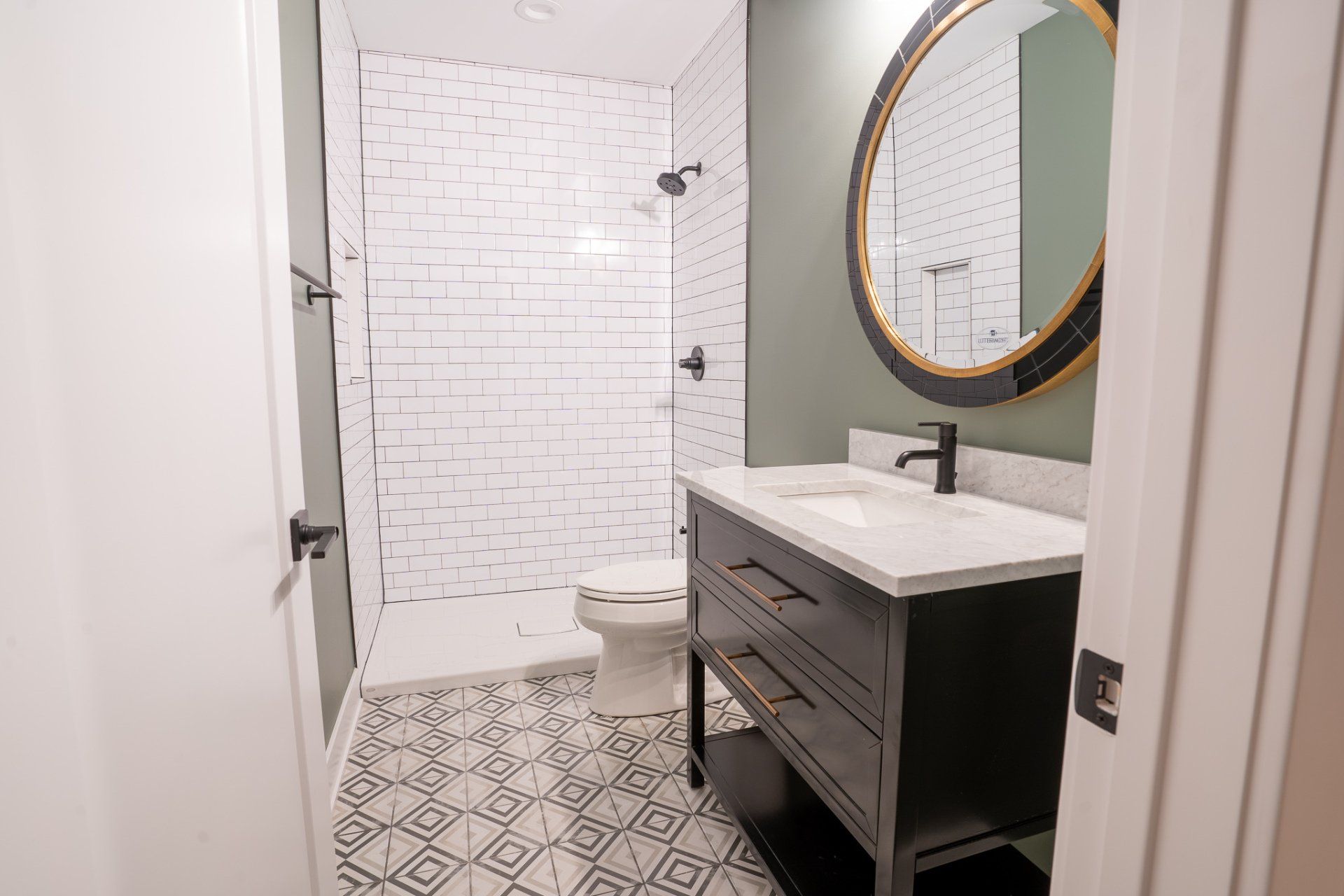 A bathroom with a toilet , sink , mirror and shower.