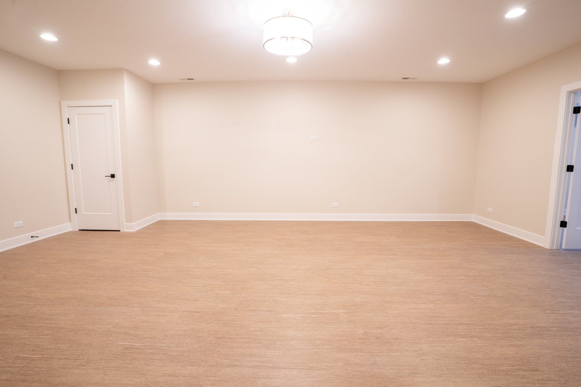An empty room with a carpeted floor and white walls.