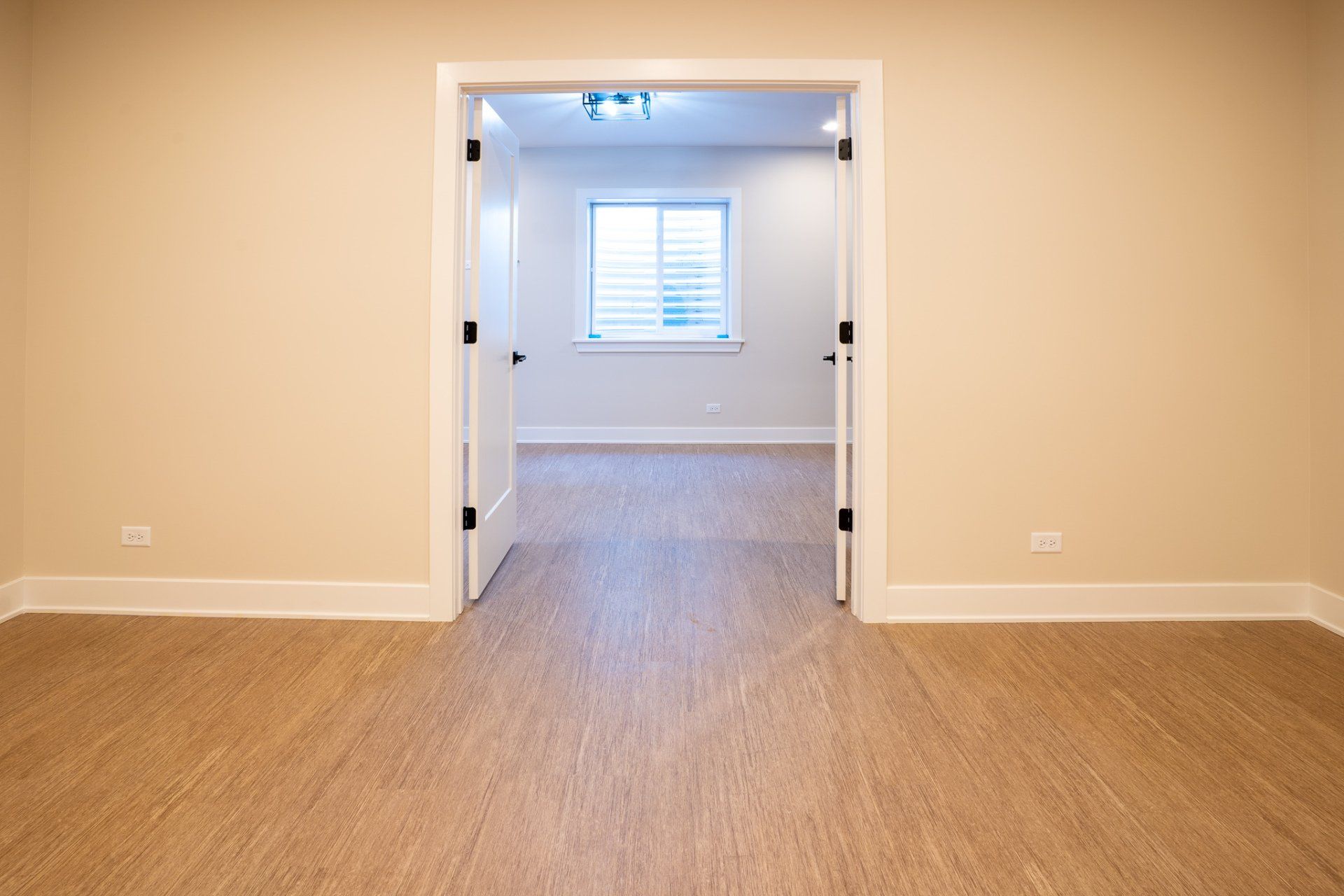 An empty room with hardwood floors and a window.
