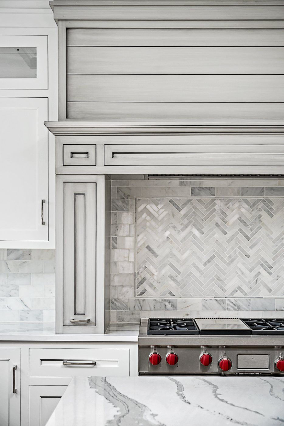 A kitchen with white cabinets and a stove top oven.