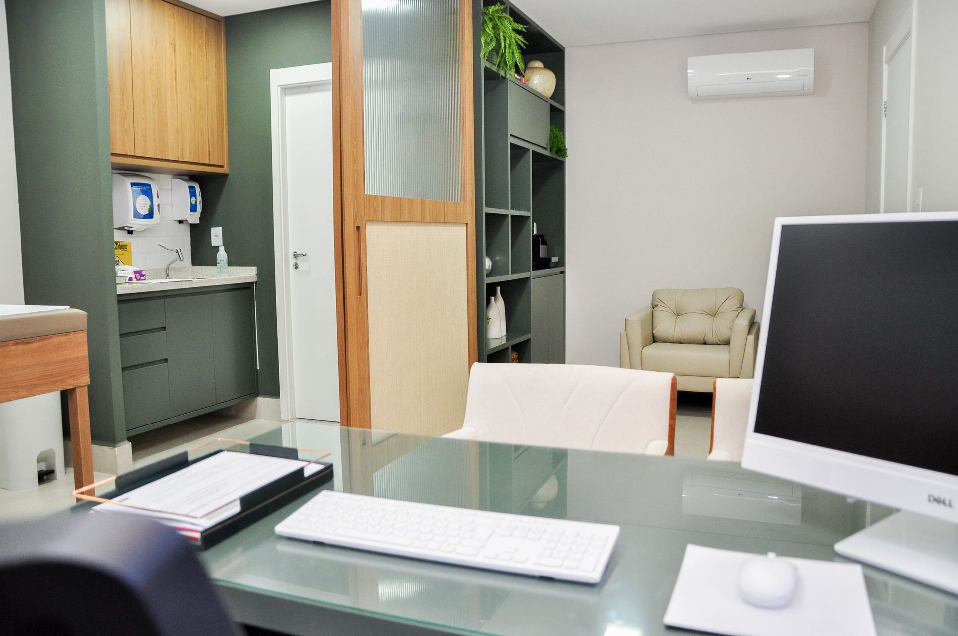 Uma mesa com um computador e um teclado em uma sala.