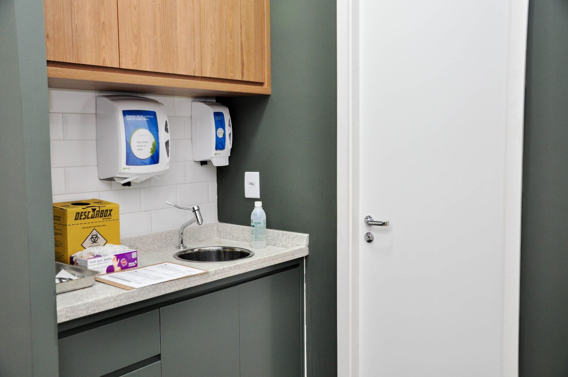 Uma cozinha com pia, armários e uma porta.