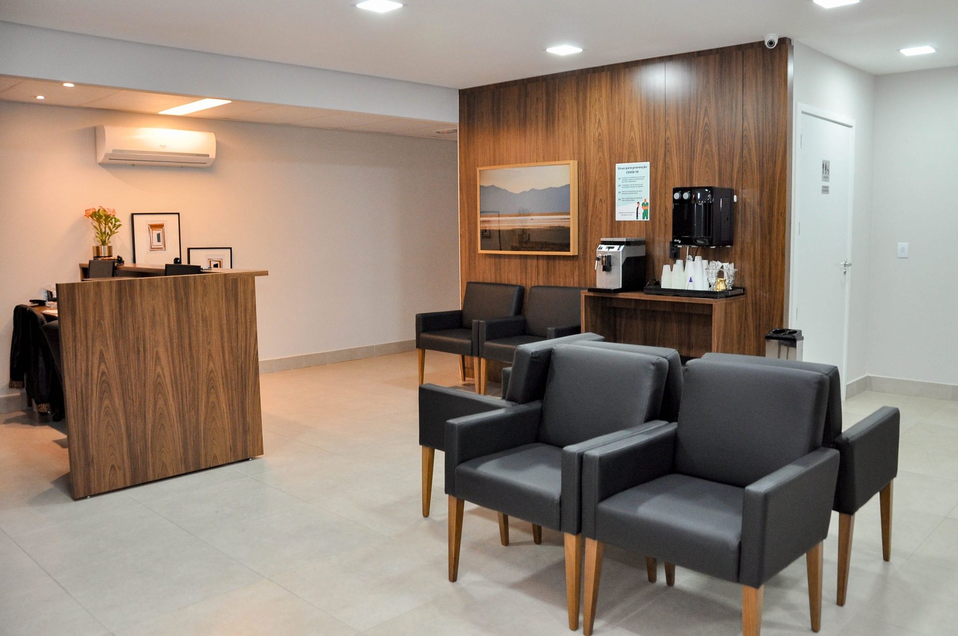 Uma sala de espera com cadeiras e um balcão em um hospital.