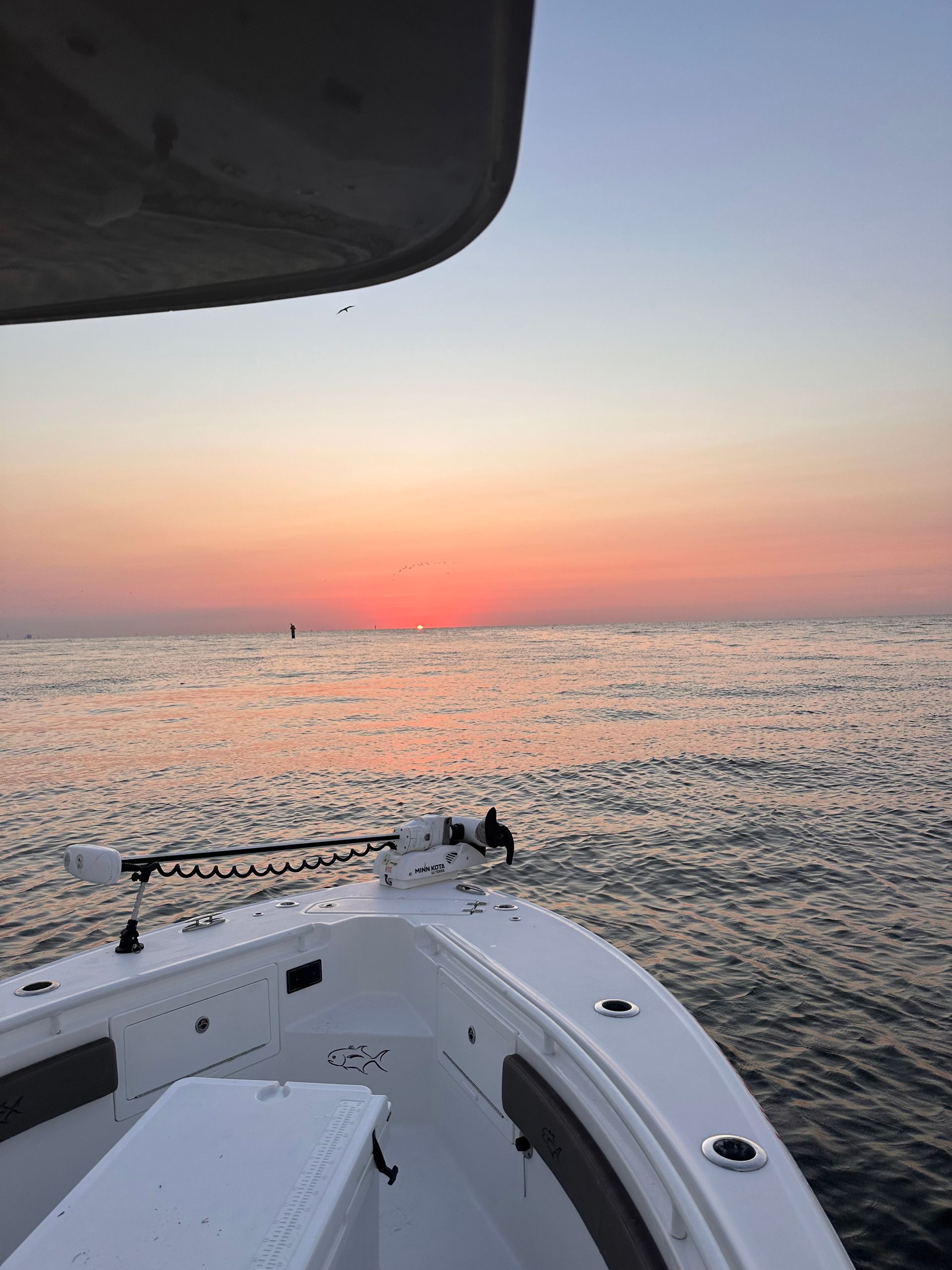 A boat in the ocean with a sunset in the background