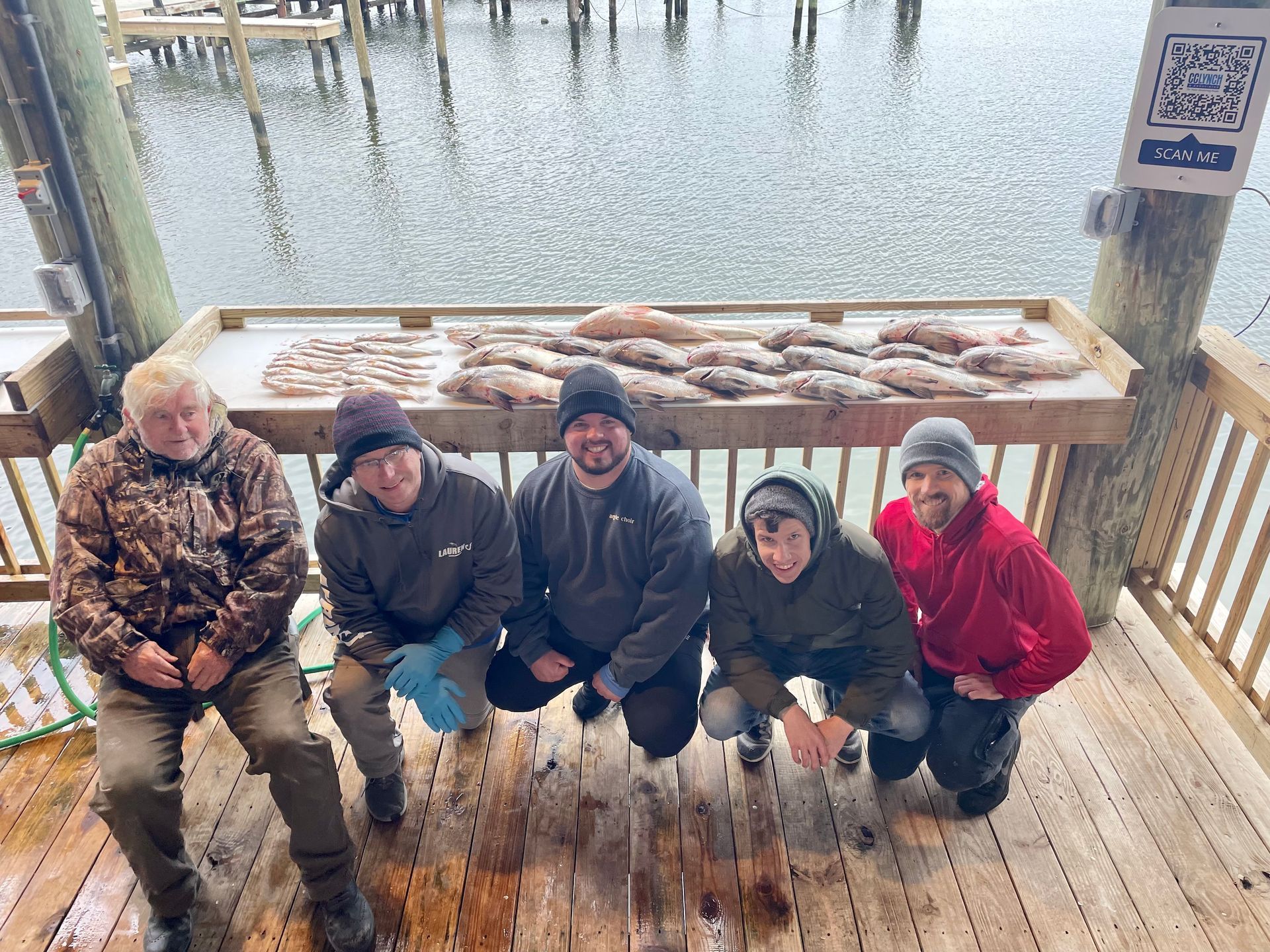 A group of men are posing for a picture on a deck.